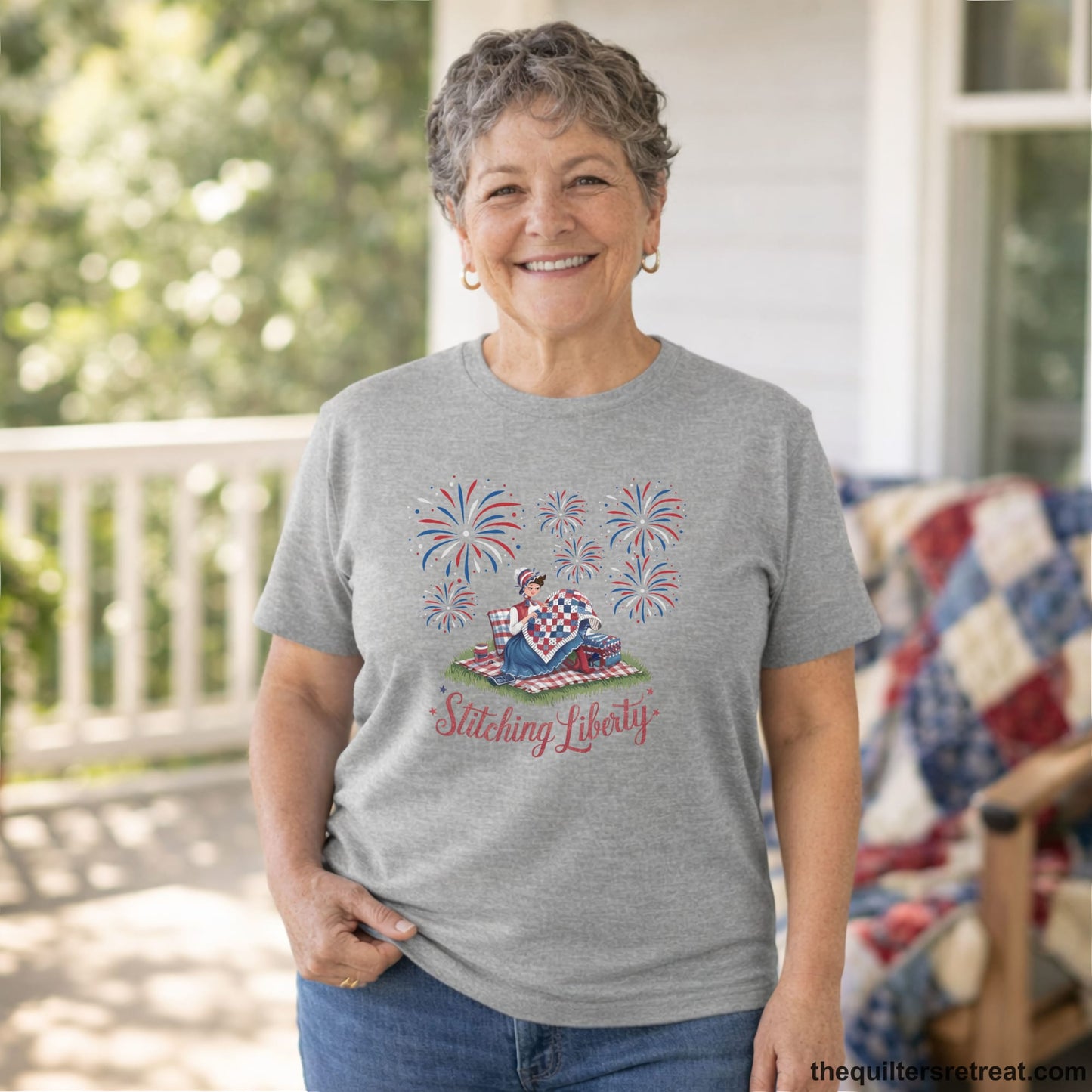 A Short Sleeve T-Shirt with a vintage illustration of woman quilting with fireworks and "Stitching Liberty" text in patriotic style