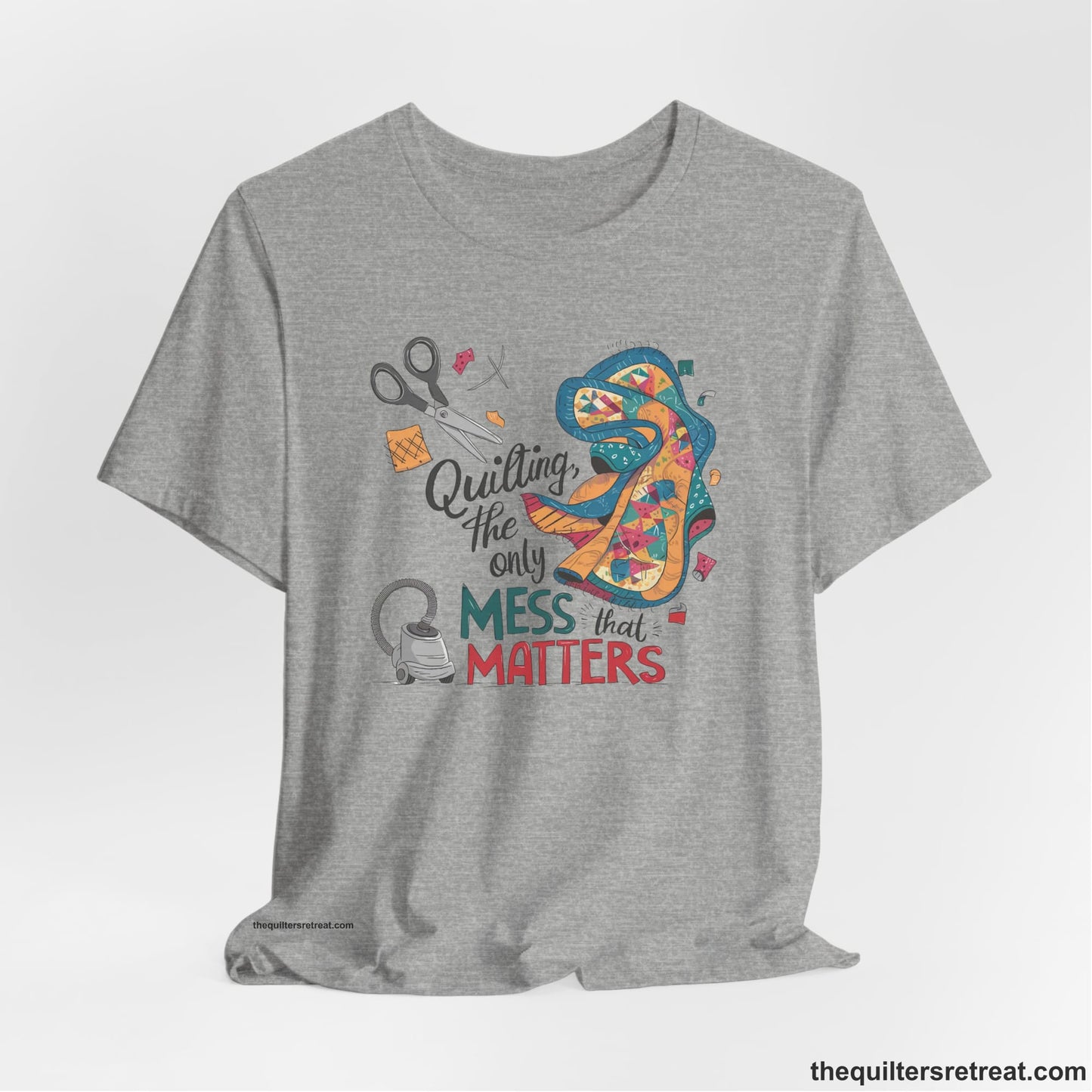 A Athletic Heather Short Sleeve T-Shirt with a quilting tools and patchwork pieces with bold "Quilting, the only mess that matters" text