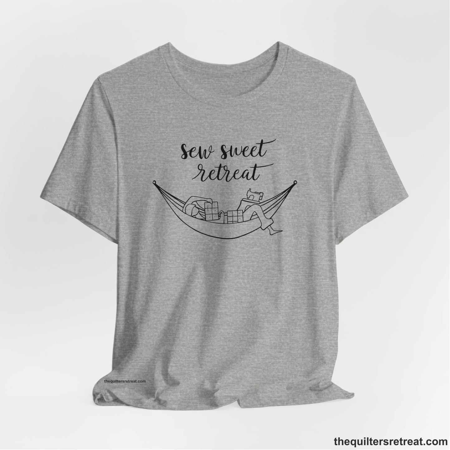 A Athletic Heather Short Sleeve T-Shirt with a sewing machine and thread spools with "Sew Sweet Retreat" in whimsical script