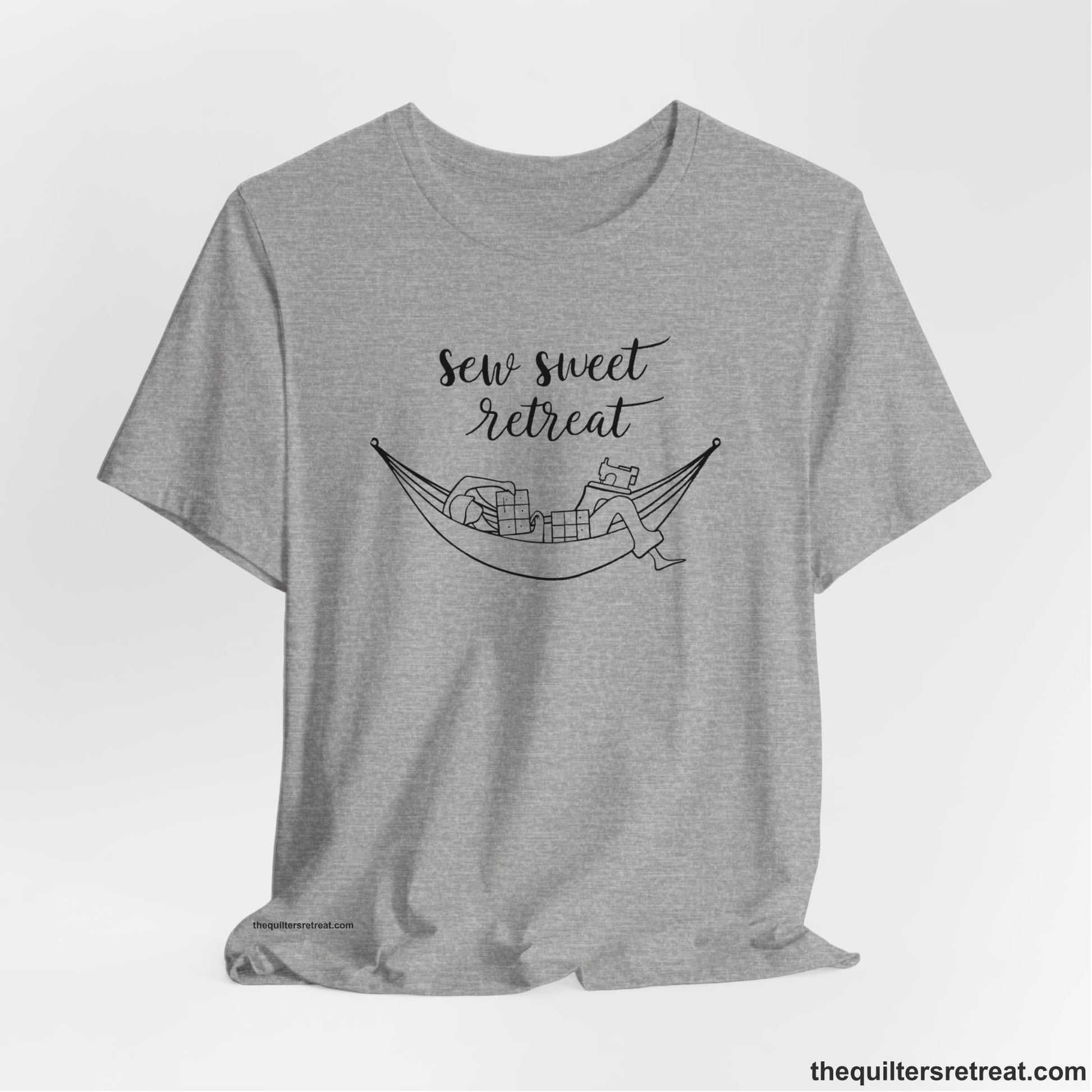 A Athletic Heather Short Sleeve T-Shirt with a sewing machine and thread spools with "Sew Sweet Retreat" in whimsical script