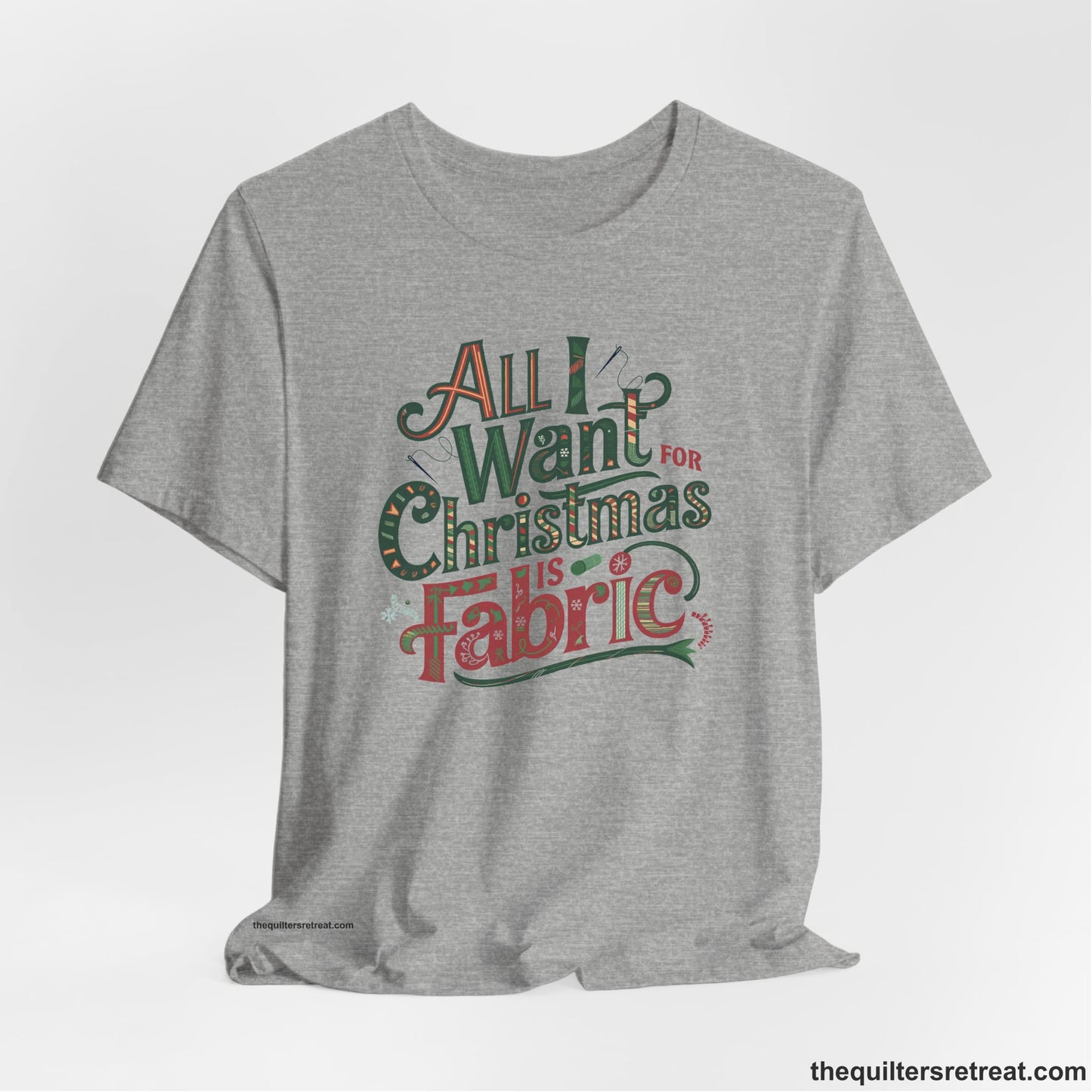 A Athletic Heather Short Sleeve T-Shirt with a vintage holiday text "All I Want for Christmas is Fabric" with festive motifs