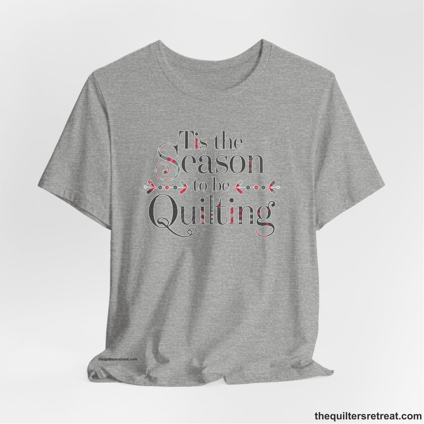 A Athletic Heather Short Sleeve T-Shirt with a tis the season to be quilting text with festive patchwork pattern in a cheerful style