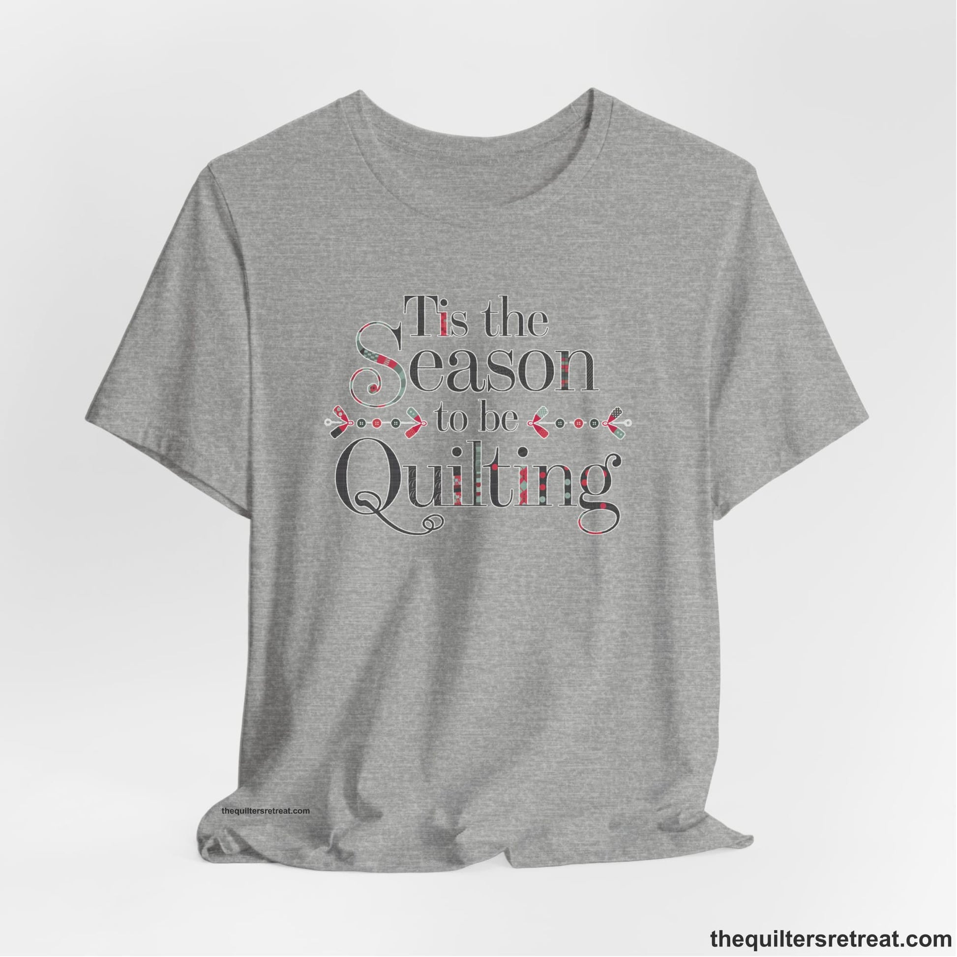 A Athletic Heather Short Sleeve T-Shirt with a tis the season to be quilting text with festive patchwork pattern in a cheerful style