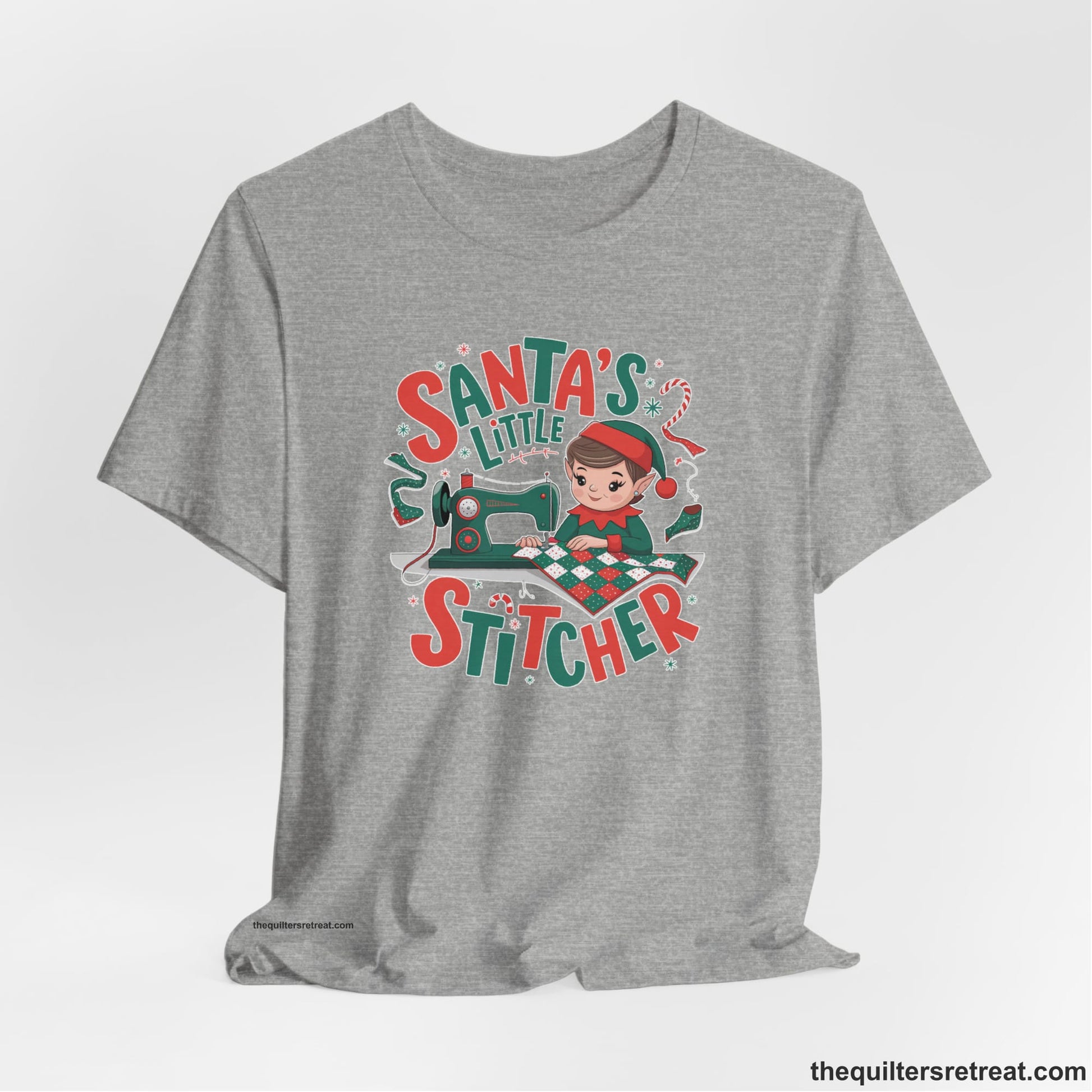 A Athletic Heather Short Sleeve T-Shirt with a santa's little stitcher elf sewing quilt with festive colors in playful style