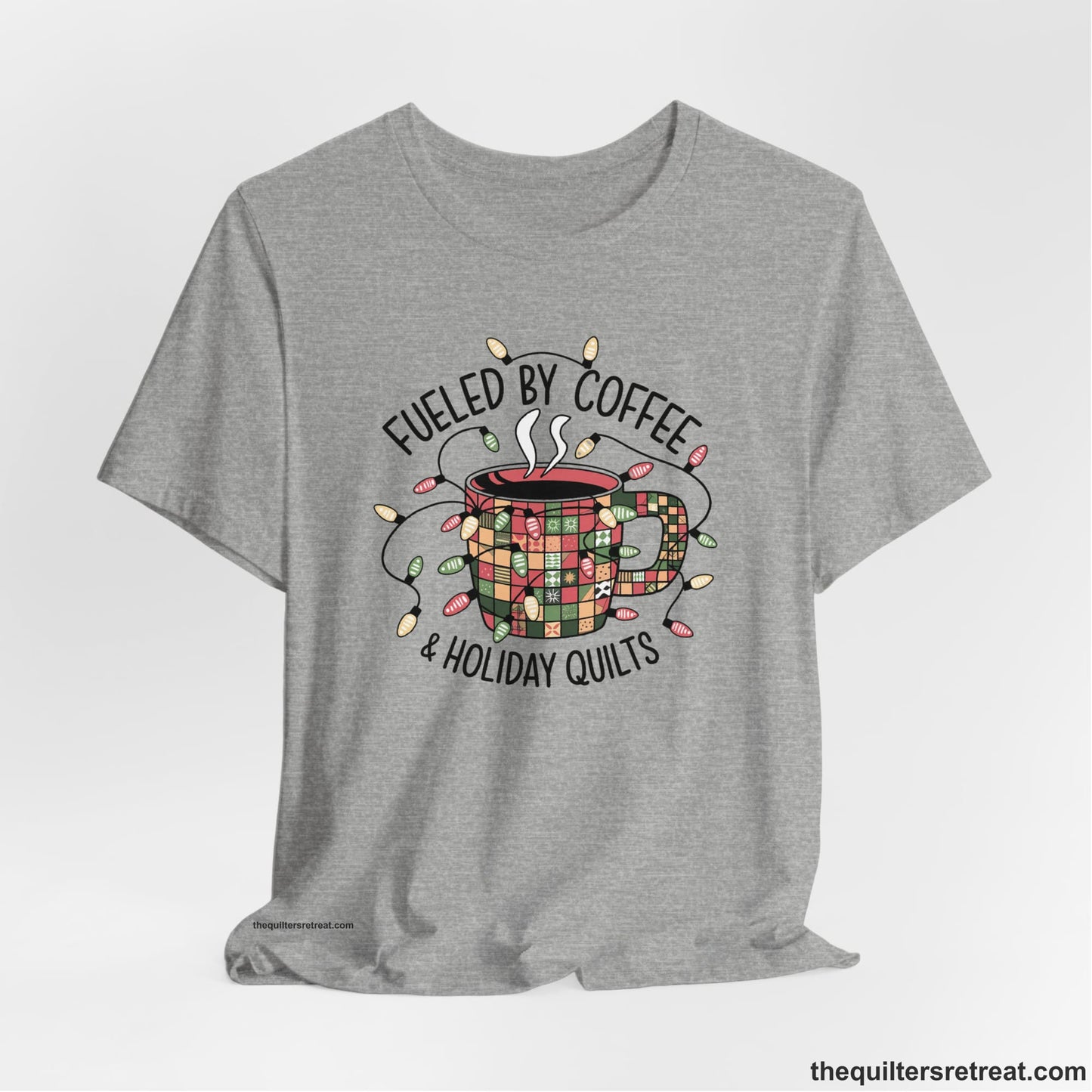 A Athletic Heather Short Sleeve T-Shirt with a patchwork coffee mug with colorful lights and subtle "Fueled by Coffee" text in festive style