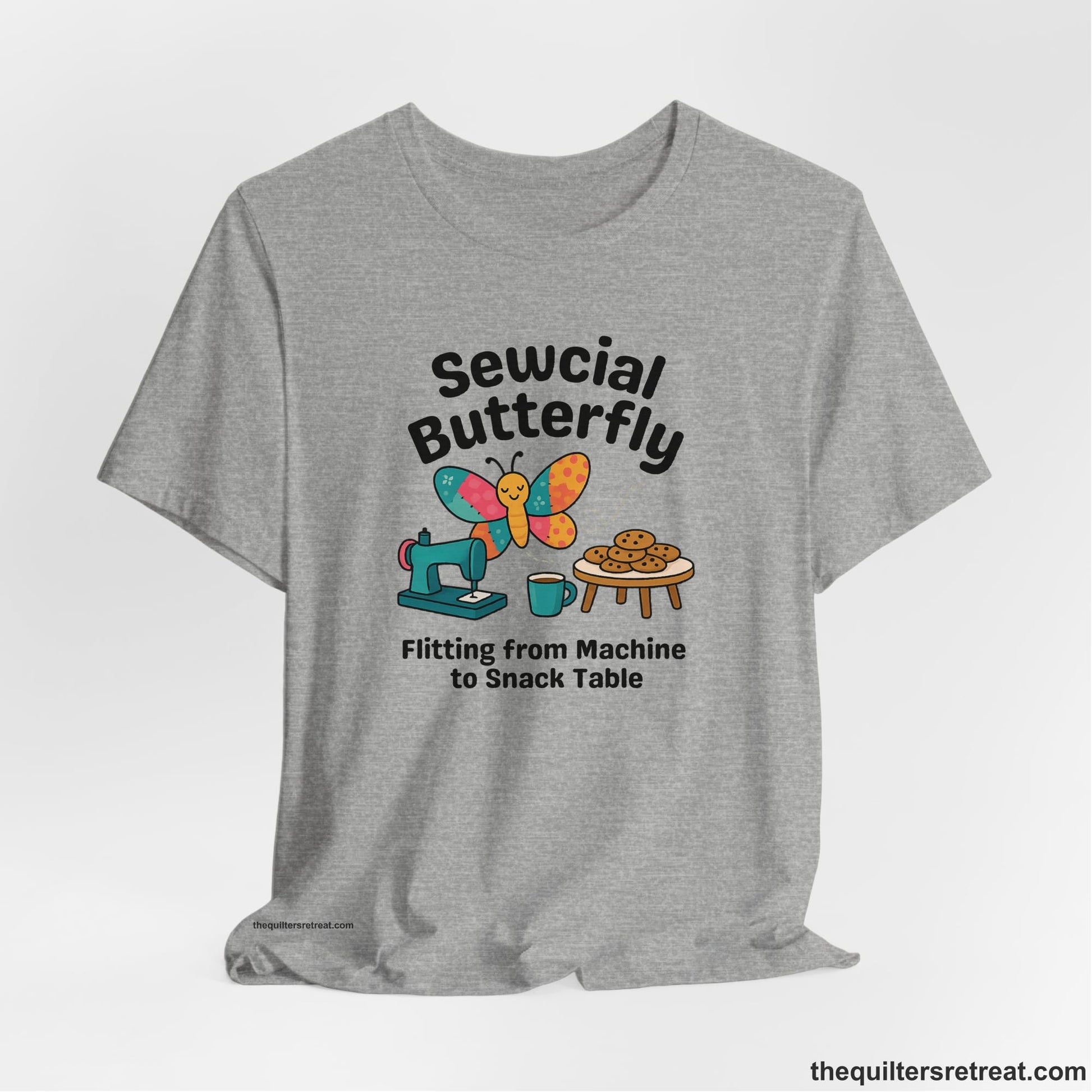 A Athletic Heather Short Sleeve T-Shirt with a playful butterfly near sewing machine with cookies and coffee doodle design