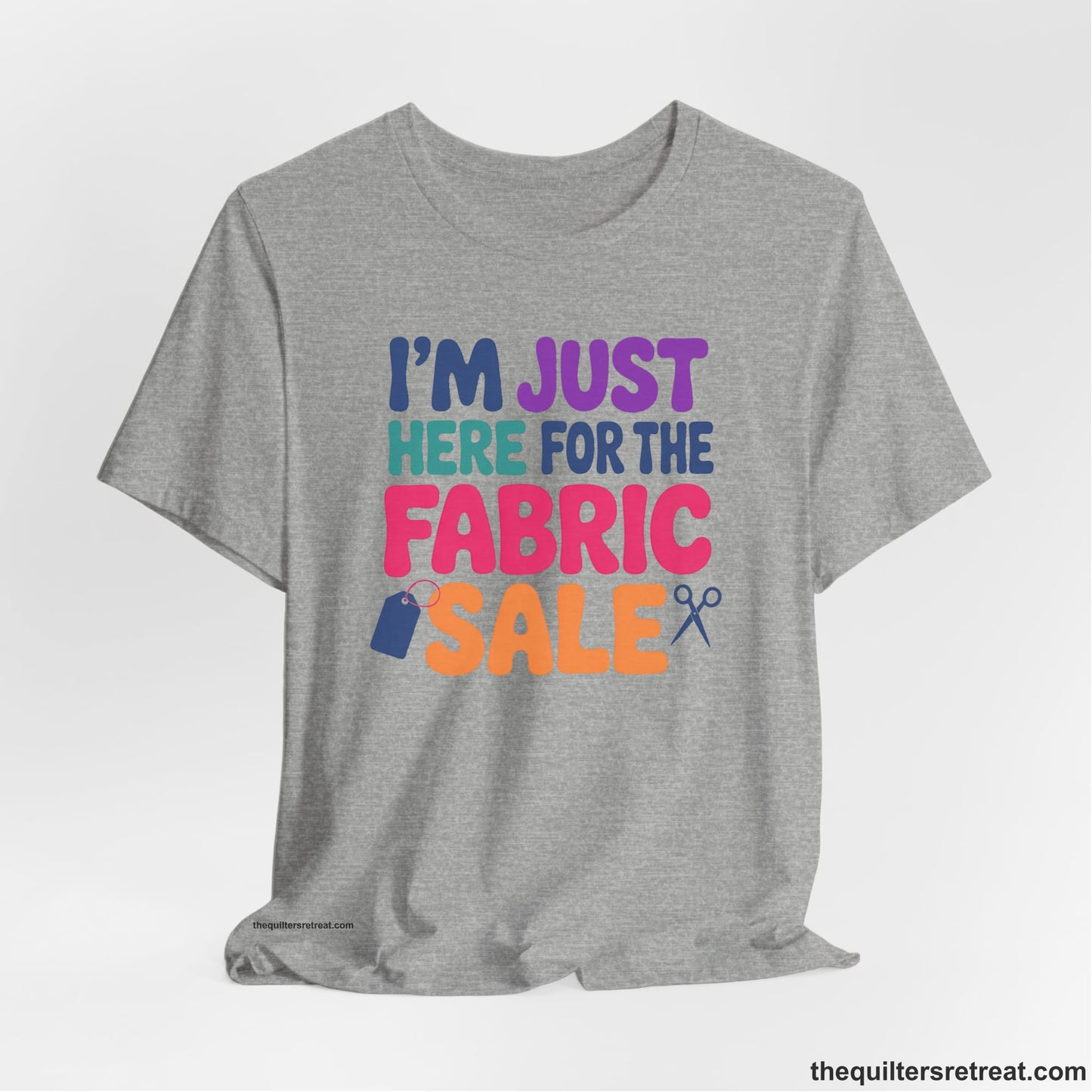 A Athletic Heather Short Sleeve T-Shirt with a playful "I'm Just Here for the Fabric Sale" text with colorful letters and sewing icons