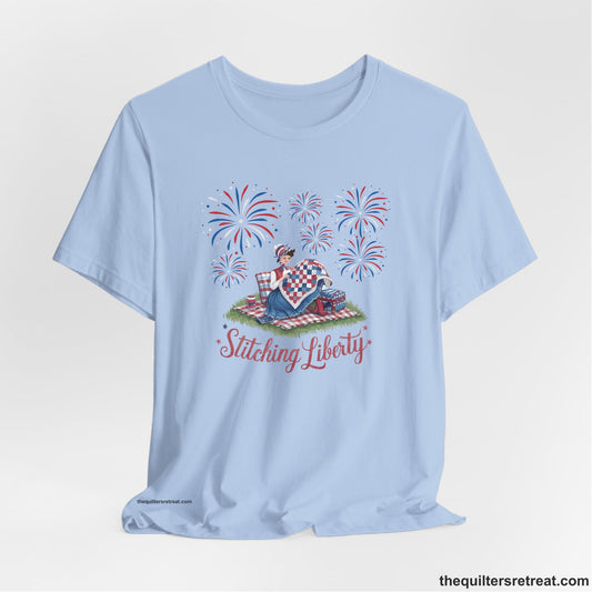 A Short Sleeve T-Shirt with a vintage illustration of woman quilting with fireworks and "Stitching Liberty" text in patriotic style