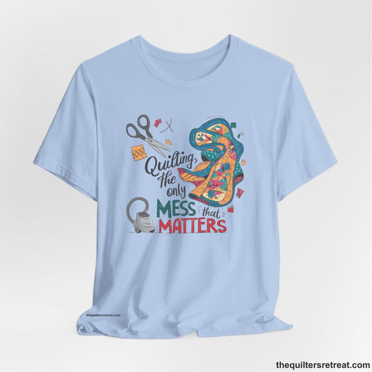 A Short Sleeve T-Shirt with a quilting tools and patchwork pieces with bold "Quilting, the only mess that matters" text