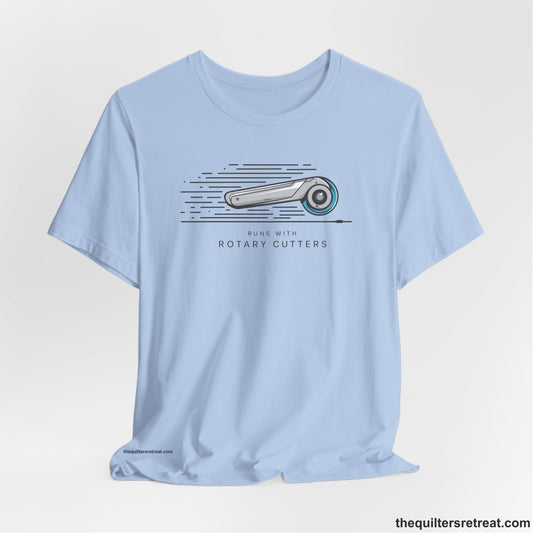 A Baby Blue Short Sleeve T-Shirt with a rotary cutter illustration with dynamic lines and bold "Runs with Rotary Cutters" text