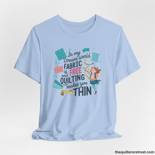 A Baby Blue Short Sleeve T-Shirt with a inspirational quilting text with playful seamstress and colorful fabric scraps in whimsical style