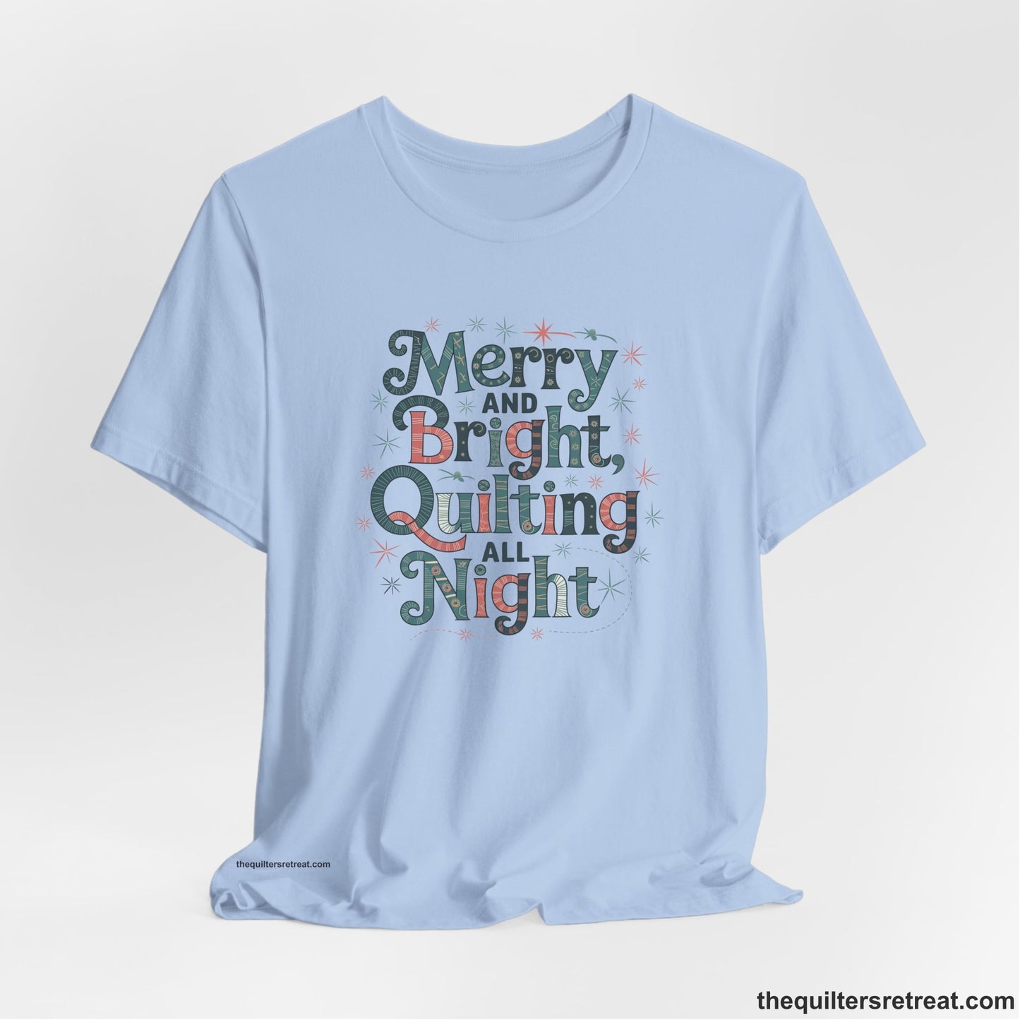 A Baby Blue Short Sleeve T-Shirt with a Merry and Bright Quilting All Night text with festive patterns and stars in a whimsical style