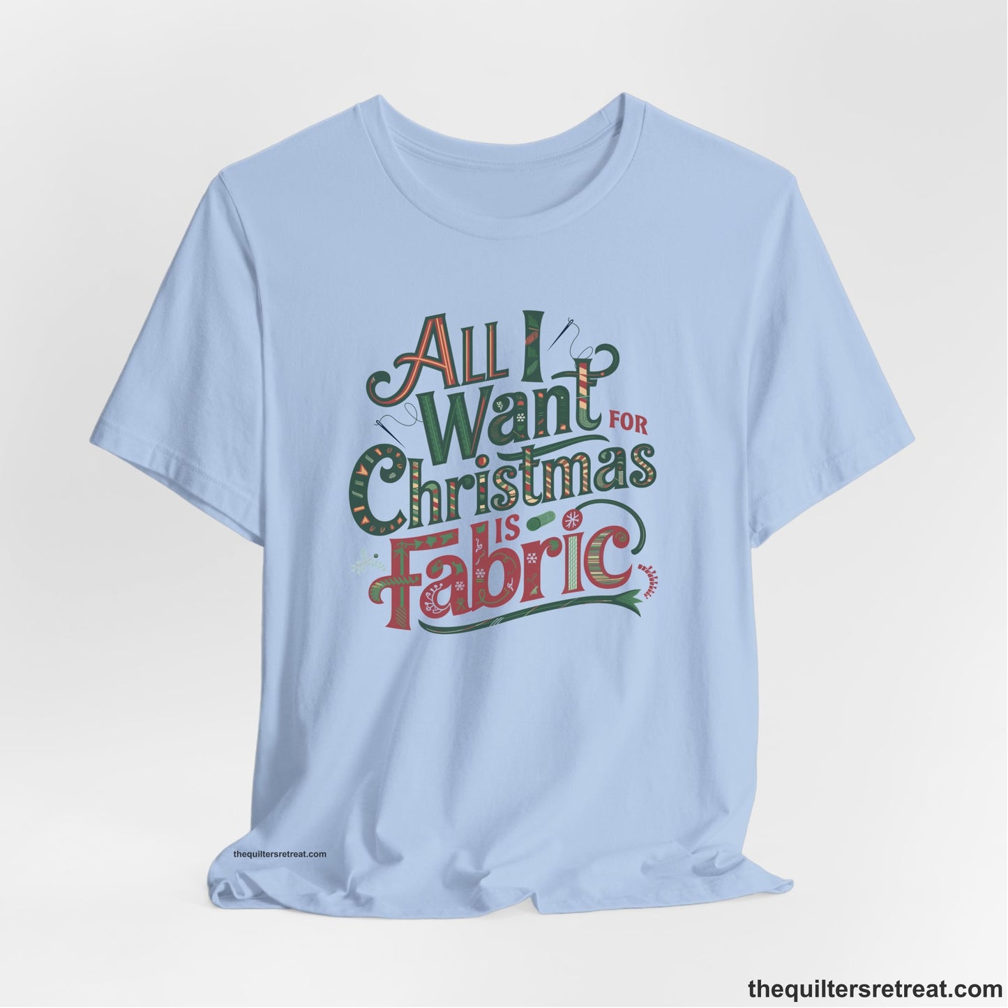 A Baby Blue Short Sleeve T-Shirt with a vintage holiday text "All I Want for Christmas is Fabric" with festive motifs
