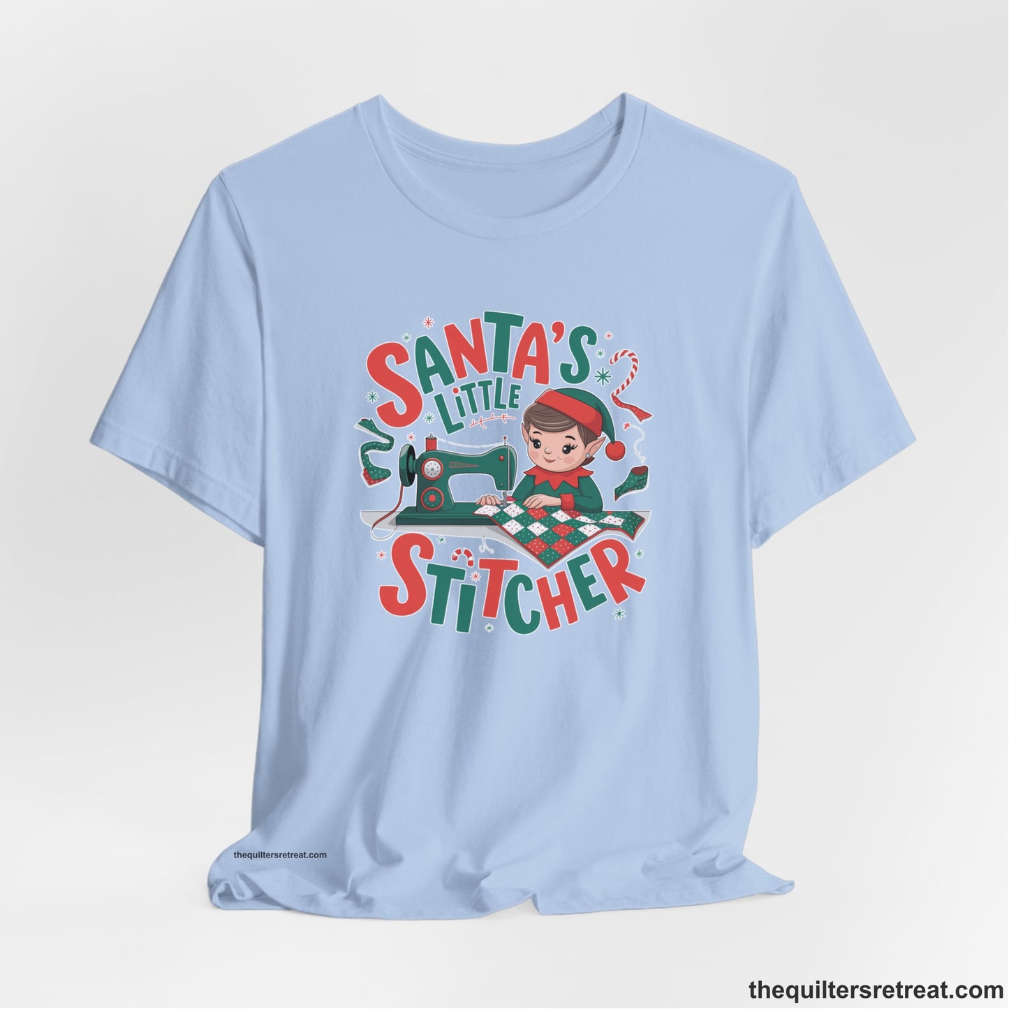A Baby Blue Short Sleeve T-Shirt with a santa's little stitcher elf sewing quilt with festive colors in playful style