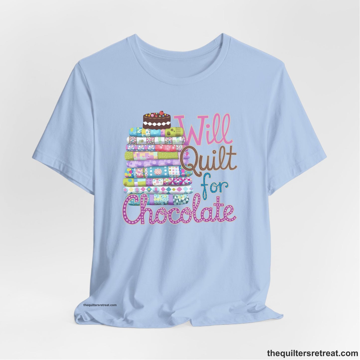 A Baby Blue Short Sleeve T-Shirt with a stack of colorful quilts topped with cake, whimsical "Will Quilt for Chocolate" text