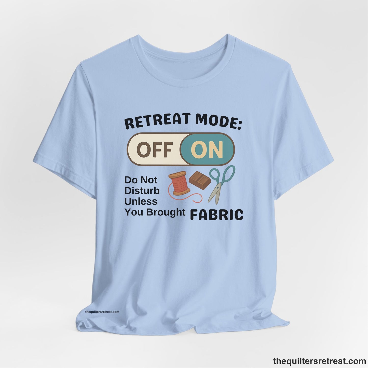 A Baby Blue Short Sleeve T-Shirt with a illustration of sewing tools with a playful "OFF ON" switch design
