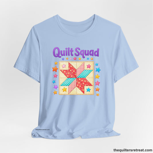 A Baby Blue Short Sleeve T-Shirt with a Patchwork quilt star with colorful stars, playful mood, "Quilt Squad" text.