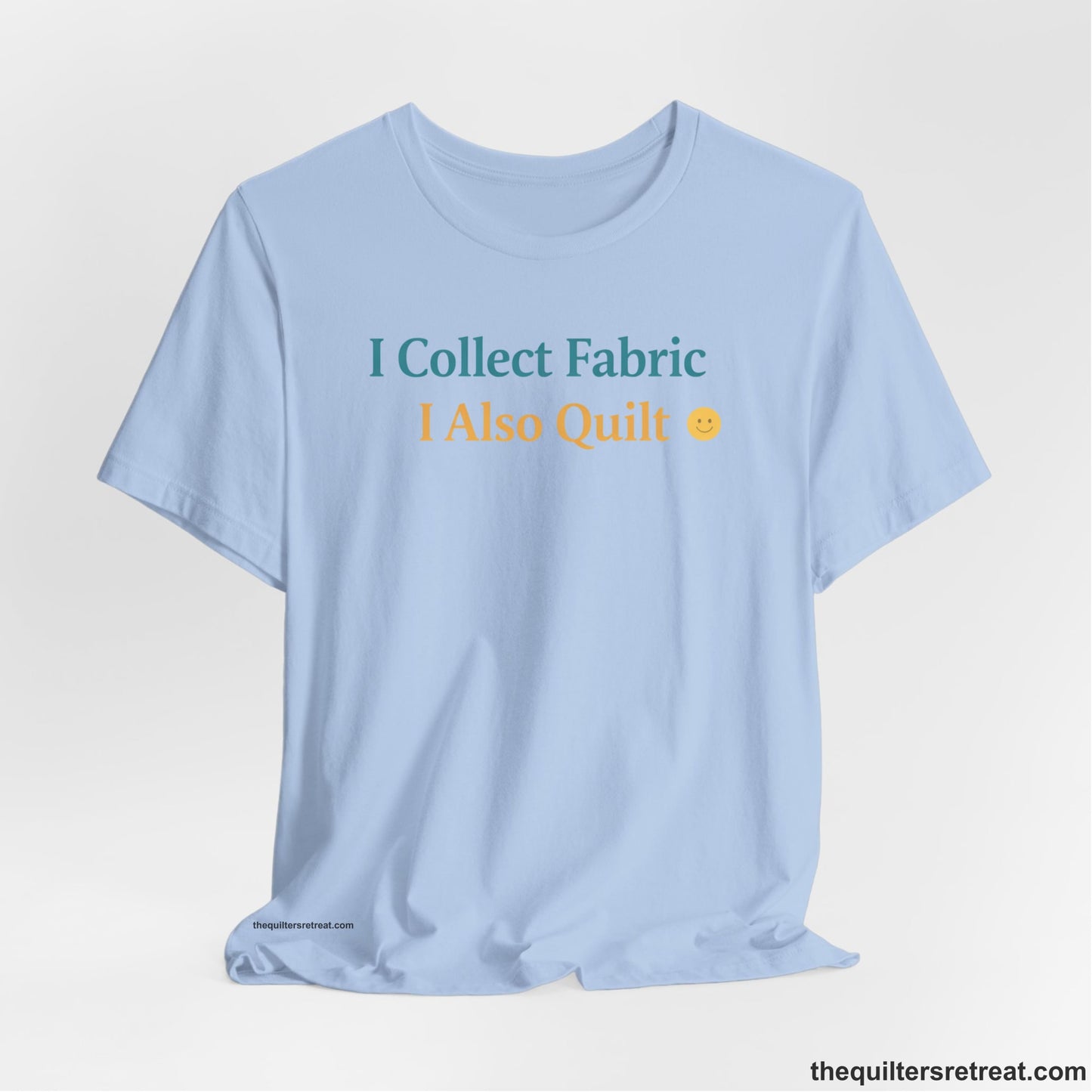 A Baby Blue Short Sleeve T-Shirt with a Colorful text saying "I Collect Fabric I Also Quilt" with a playful, cheerful vibe.