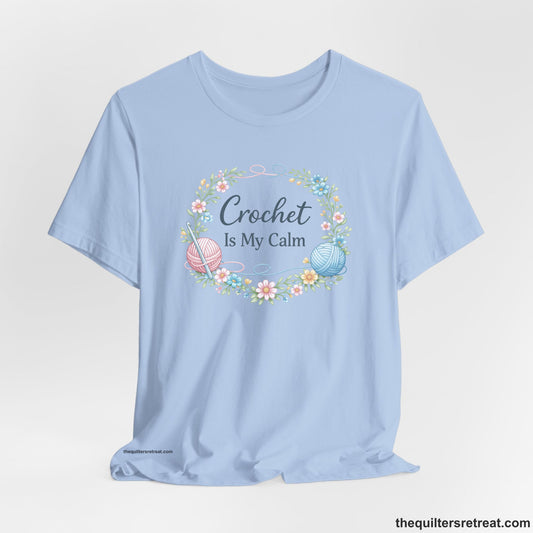 Crochet Gift: A Baby Blue Short Sleeve T-Shirt with Yarn balls and flowers wreath with "Crochet Is My Calm" in elegant script.