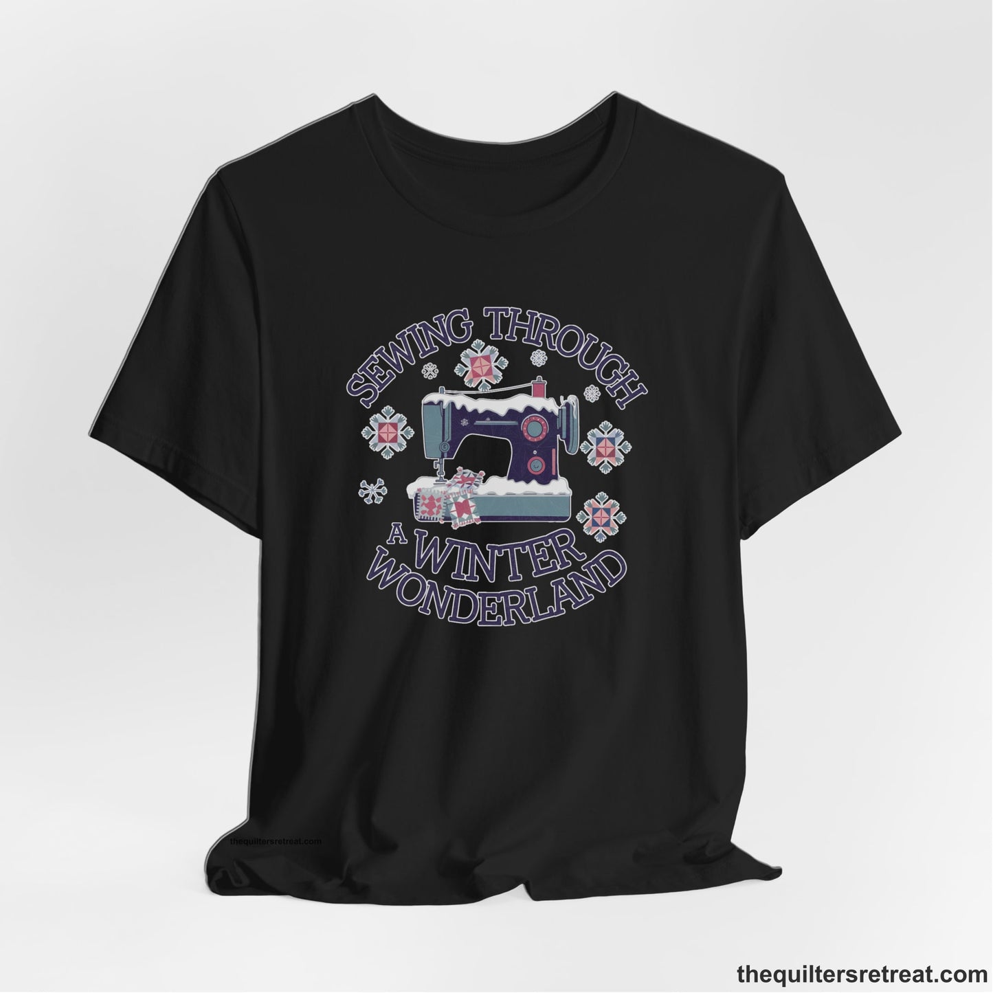 A Black Short Sleeve T-Shirt with a sewing machine covered in snow with festive quilting elements and "Sewing Through a Winter Wonderland" text
