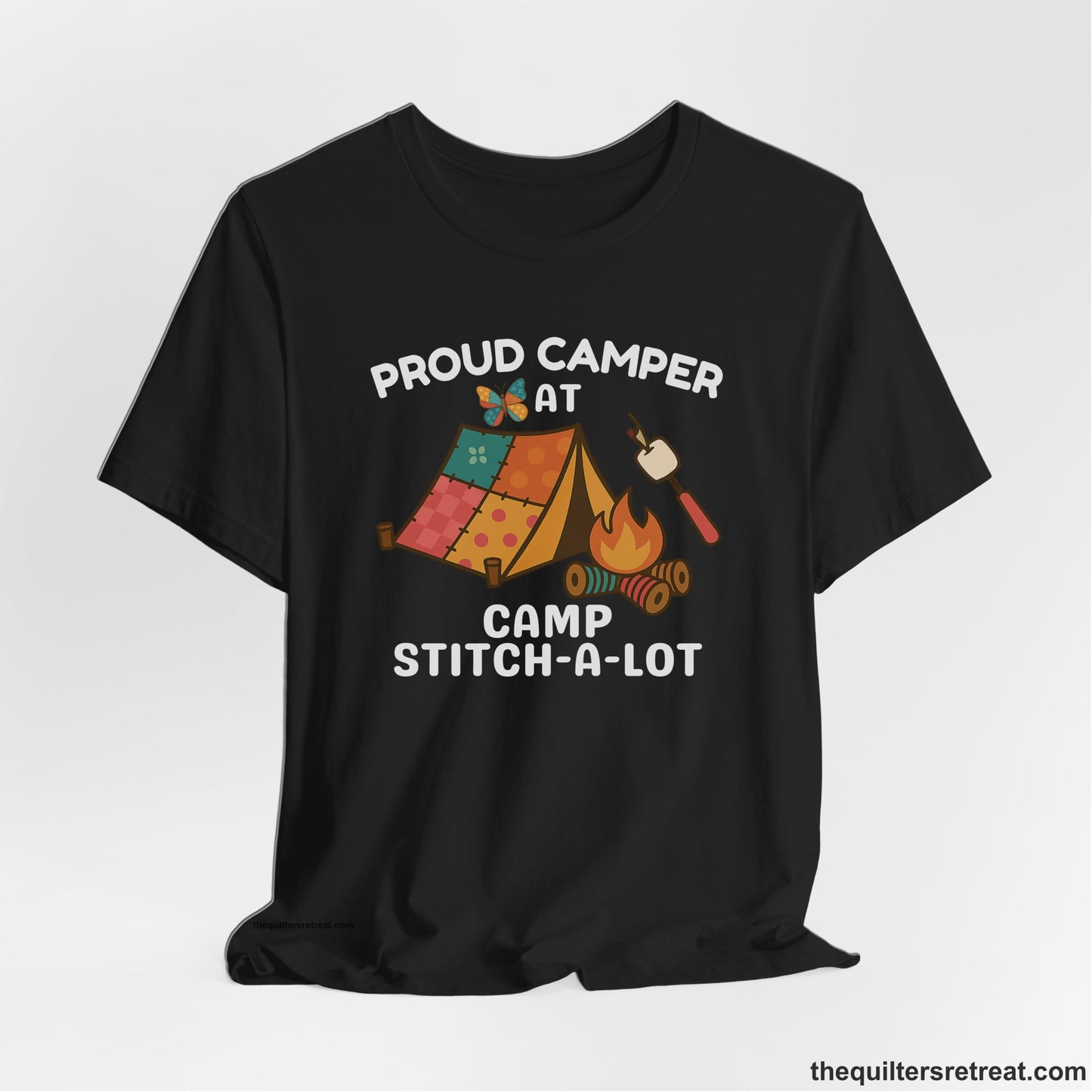 A Black Short Sleeve T-Shirt with a camping scene with patchwork tent, campfire, and whimsical butterfly and marshmallow illustration