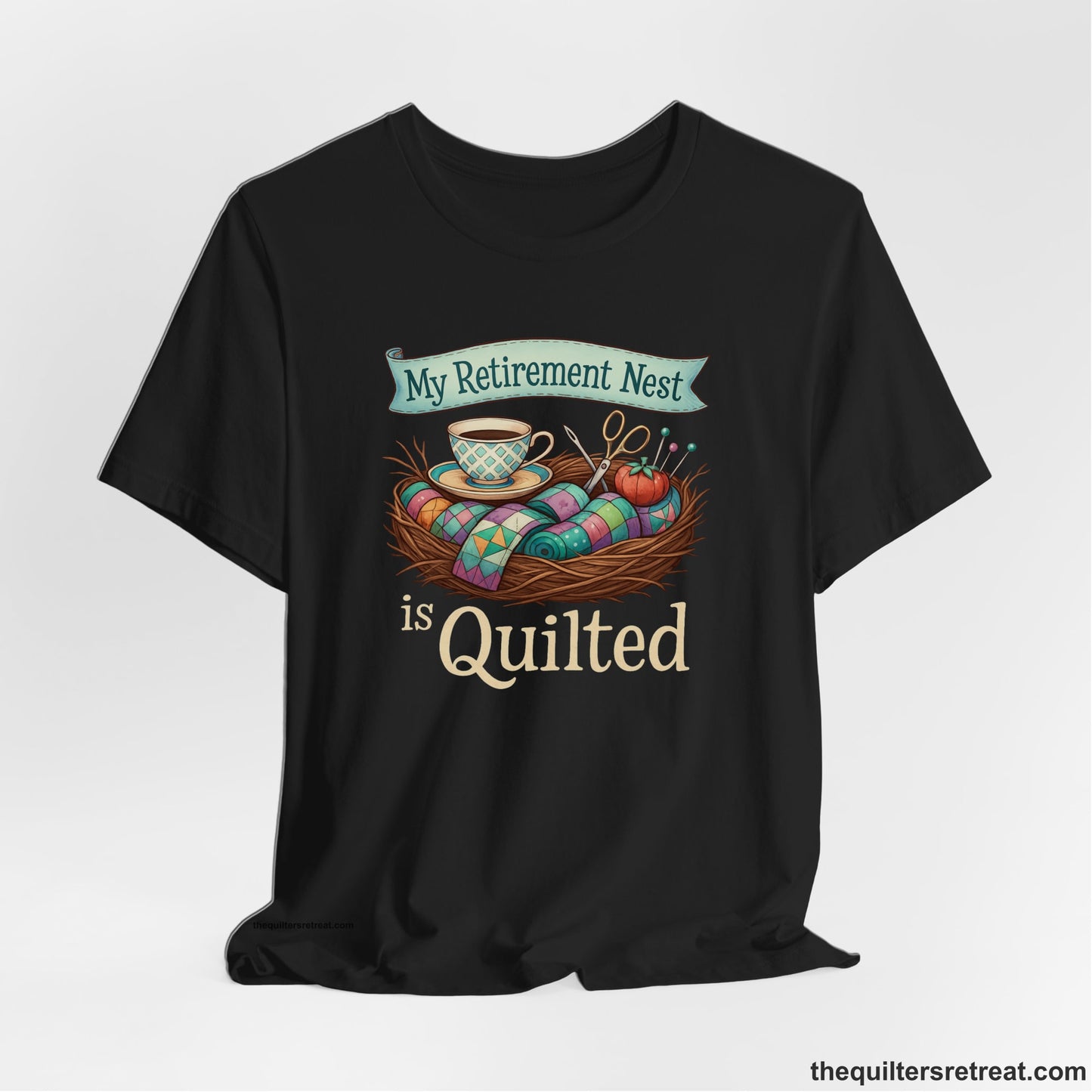 A Black Short Sleeve T-Shirt with a My Retirement Nest is Quilted text with a cozy sewing elements illustration