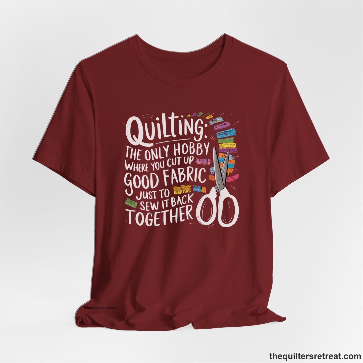 A Cardinal Short Sleeve T-Shirt with a quilting-themed text with colorful fabric pieces and scissors in a whimsical style