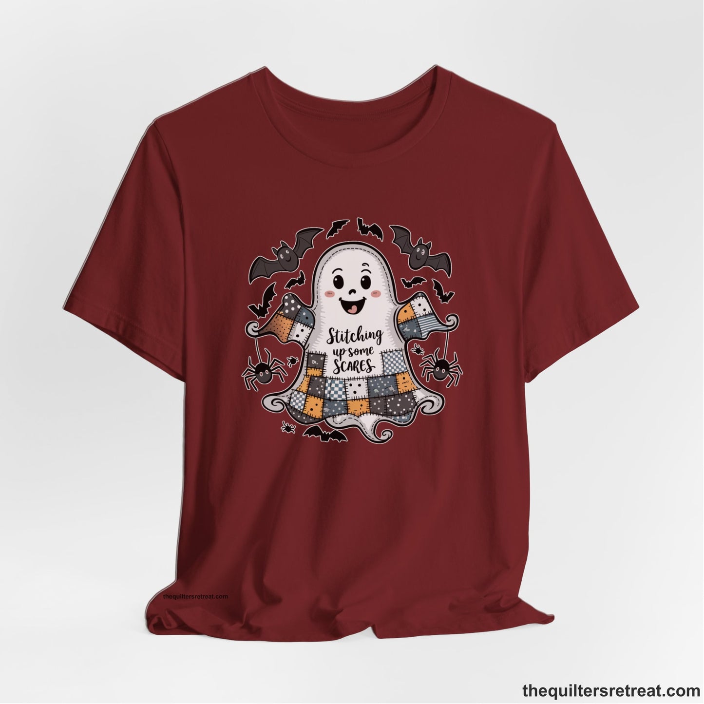 A Cardinal Short Sleeve T-Shirt with a cute patchwork ghost with "Stitching up some Scares" text and playful bats in a whimsical style