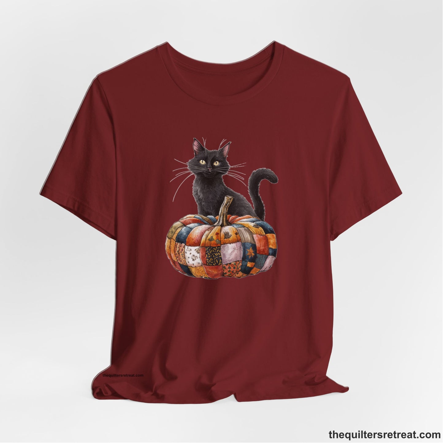 A Cardinal Short Sleeve T-Shirt with a black cat with a quilted patchwork pumpkin in a whimsical autumn style