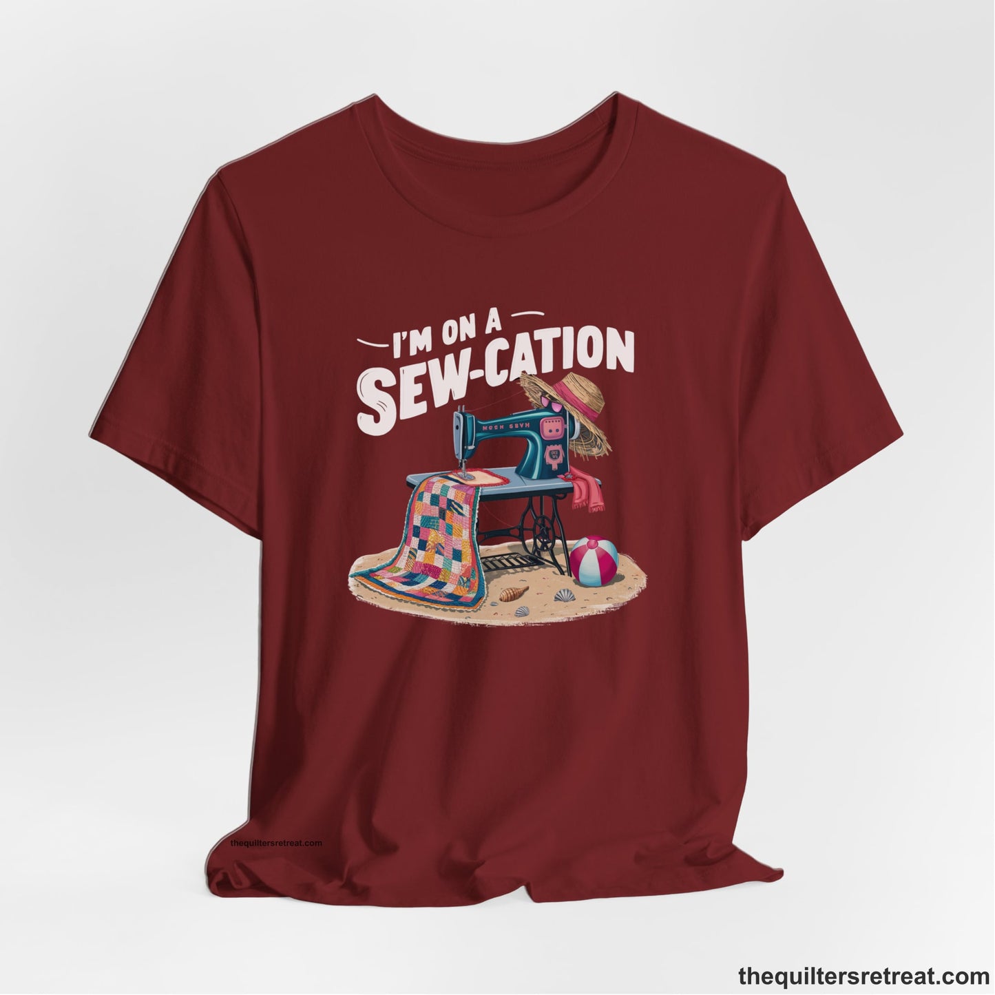 A Cardinal Short Sleeve T-Shirt with a vintage sewing machine with colorful quilt, beach items, and "I'm On A Sew-Cation" text