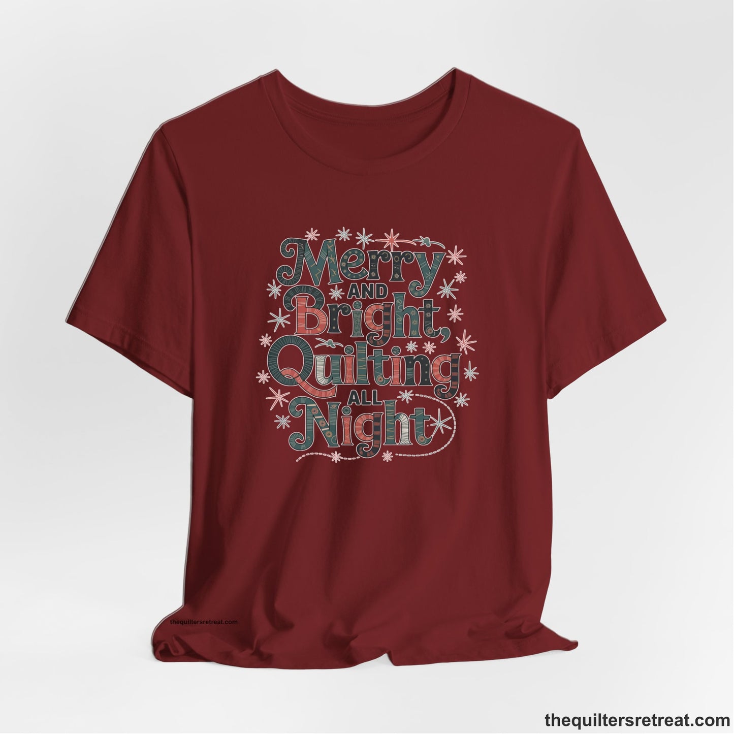 A Cardinal Short Sleeve T-Shirt with a Merry and Bright Quilting All Night text with festive patterns and stars in a whimsical style