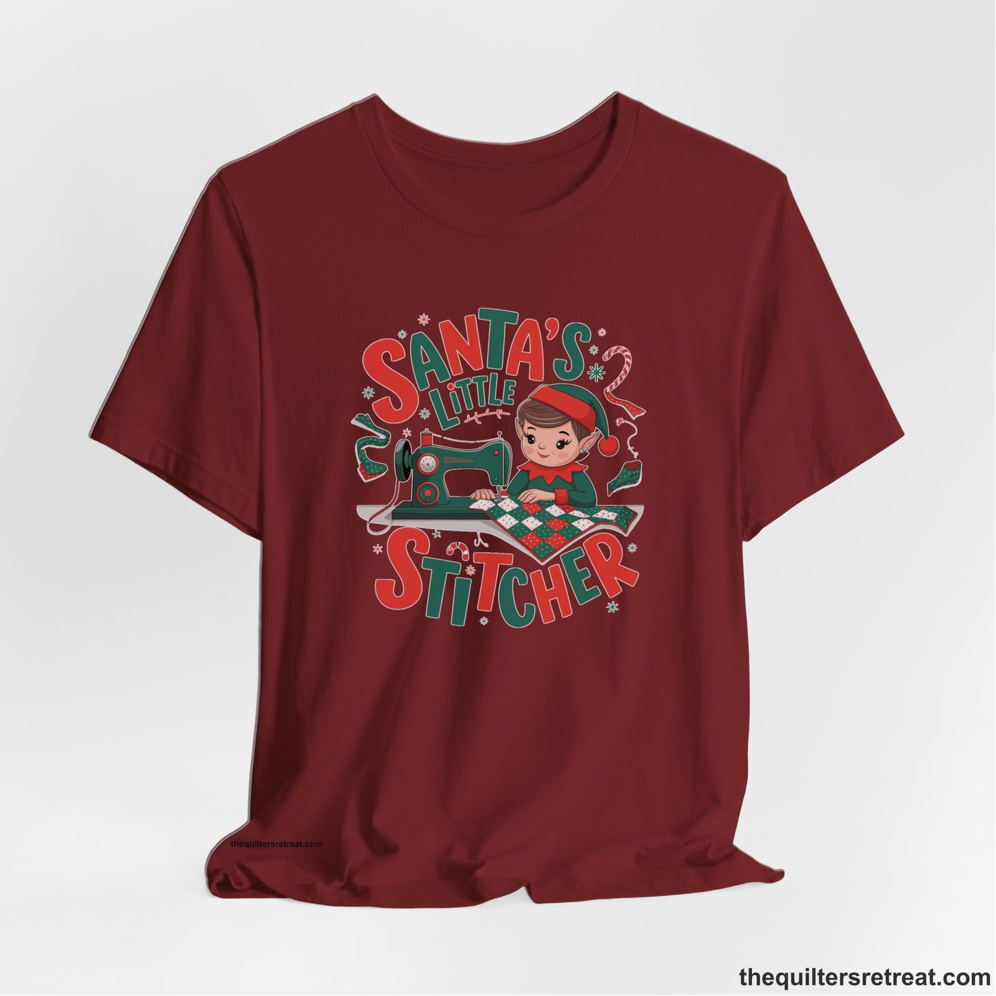 A Cardinal Short Sleeve T-Shirt with a santa's little stitcher elf sewing quilt with festive colors in playful style