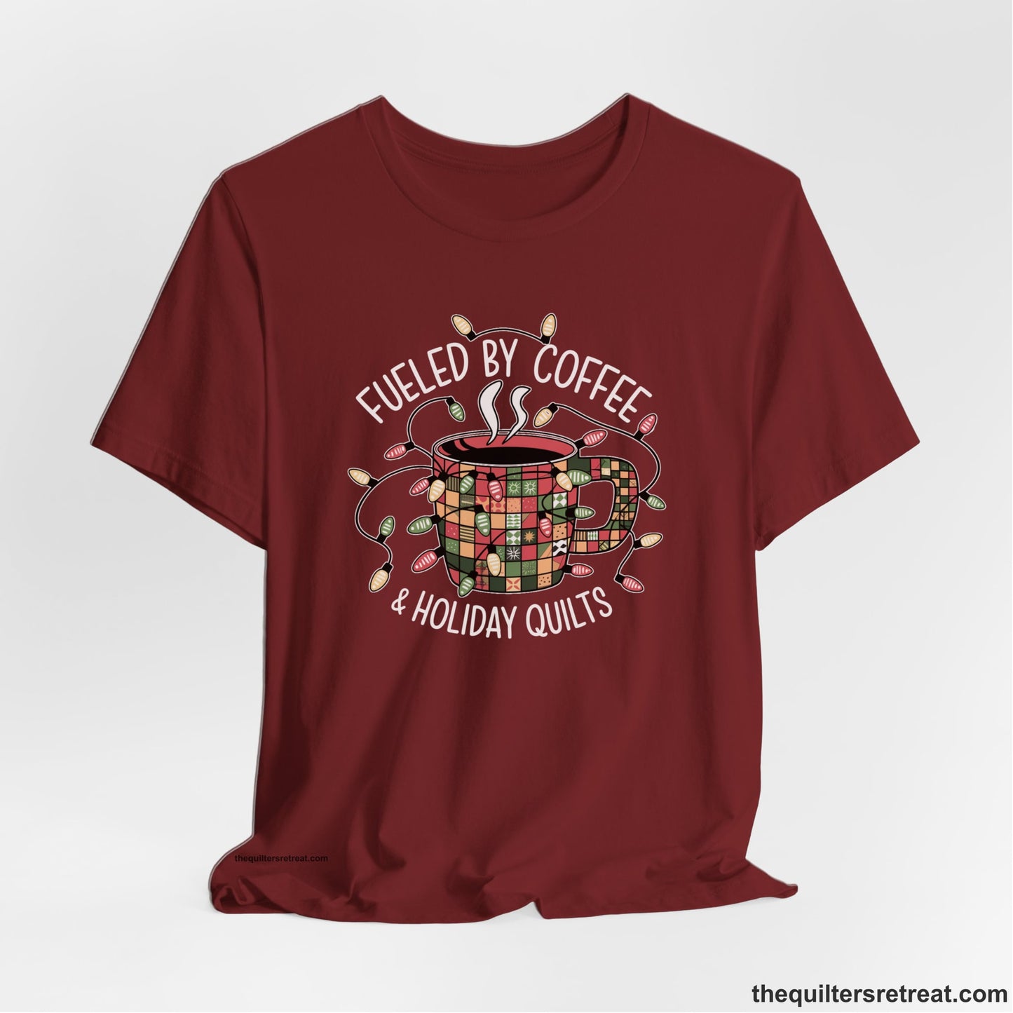 A Cardinal Short Sleeve T-Shirt with a patchwork coffee mug with colorful lights and subtle "Fueled by Coffee" text in festive style