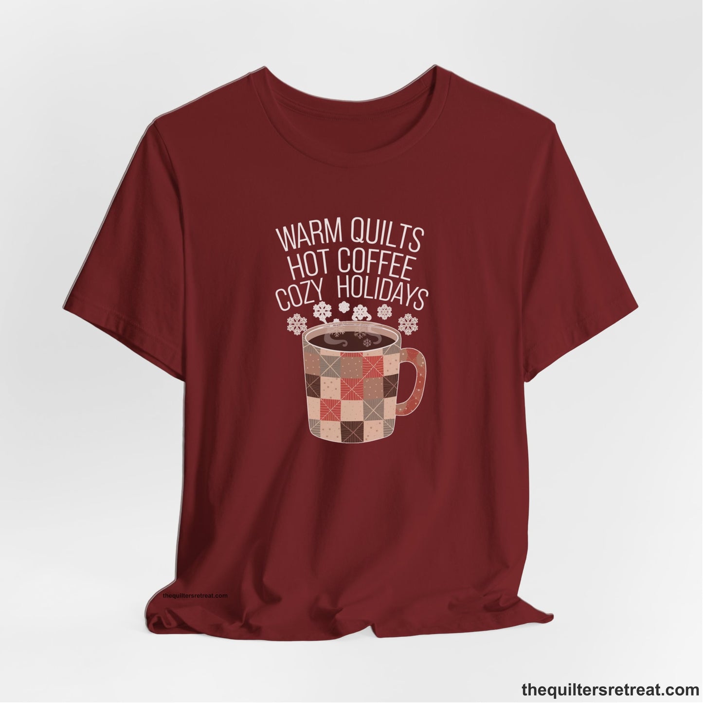 A Cardinal Short Sleeve T-Shirt with a warm quilts hot coffee cozy holidays text with a patchwork mug and snowflakes