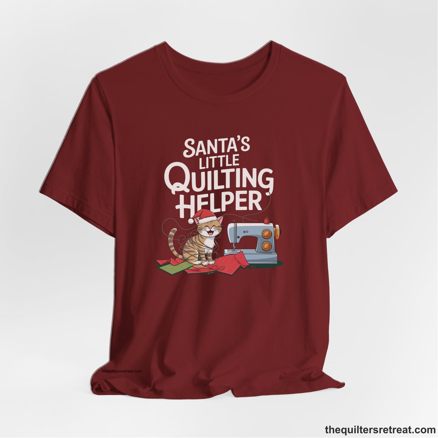 A Cardinal Short Sleeve T-Shirt with a santa-hat-wearing kitten with a sewing machine and "Santa's Little Quilting Helper" text in playful style