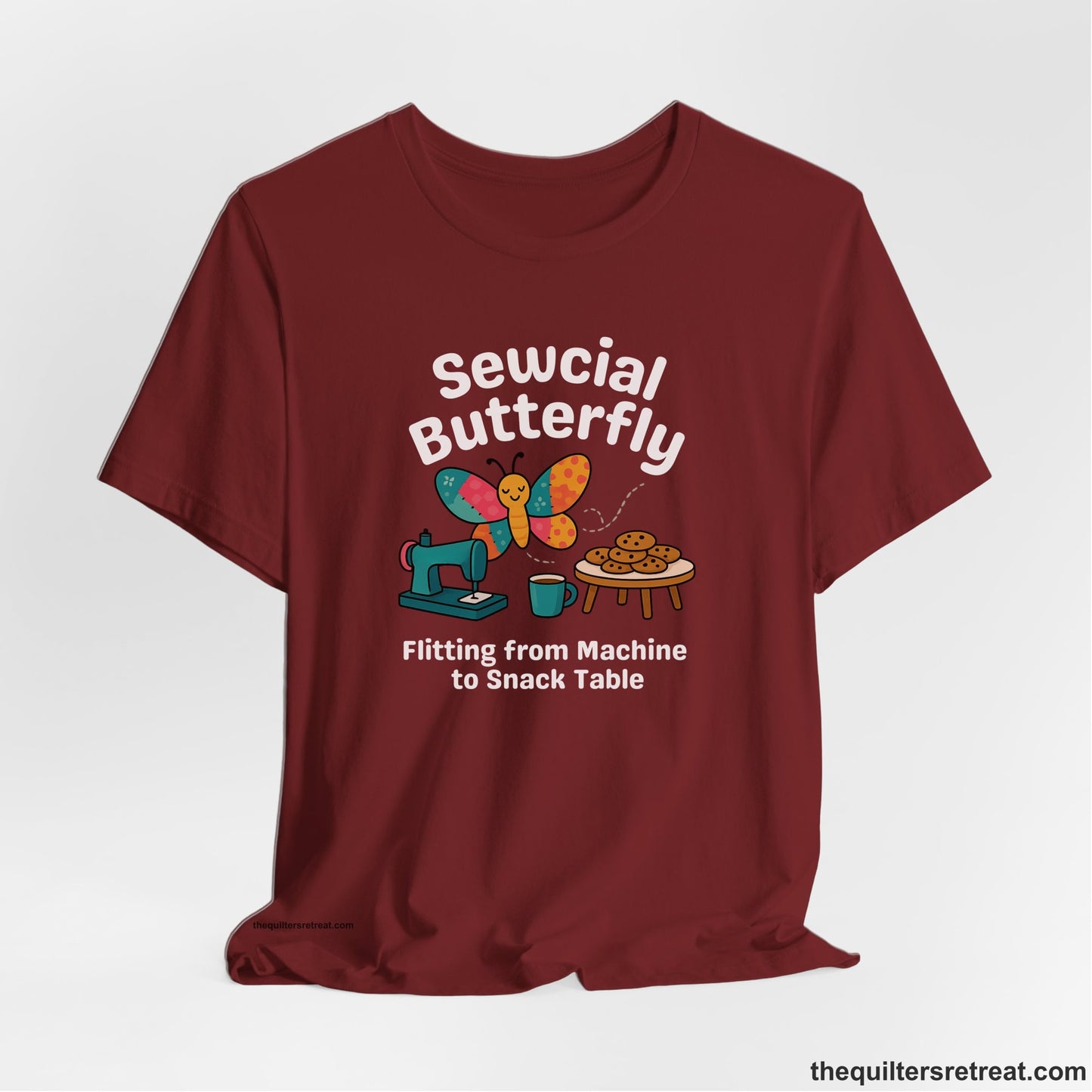 A Cardinal Short Sleeve T-Shirt with a playful butterfly near sewing machine with cookies and coffee doodle design