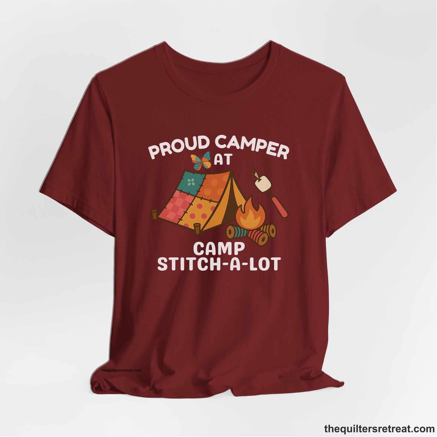 A Cardinal Short Sleeve T-Shirt with a camping scene with patchwork tent, campfire, and whimsical butterfly and marshmallow illustration