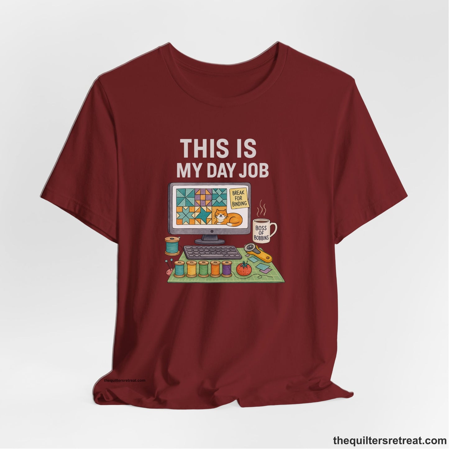 A Cardinal Short Sleeve T-Shirt with a computer quilt design, cat illustration, "THIS IS MY DAY JOB" text with sewing tools, playful style
