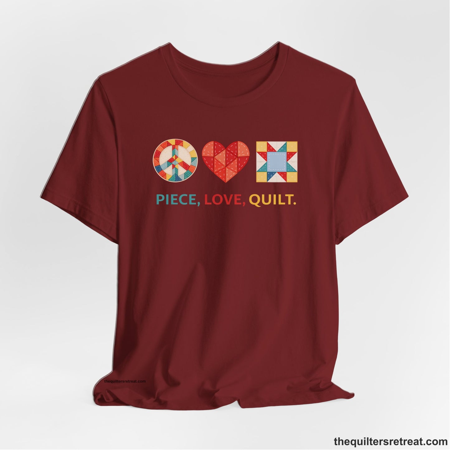 A Cardinal Short Sleeve T-Shirt with a Colorful quilt patterns, "PIECE, LOVE, QUILT." text, whimsical style.