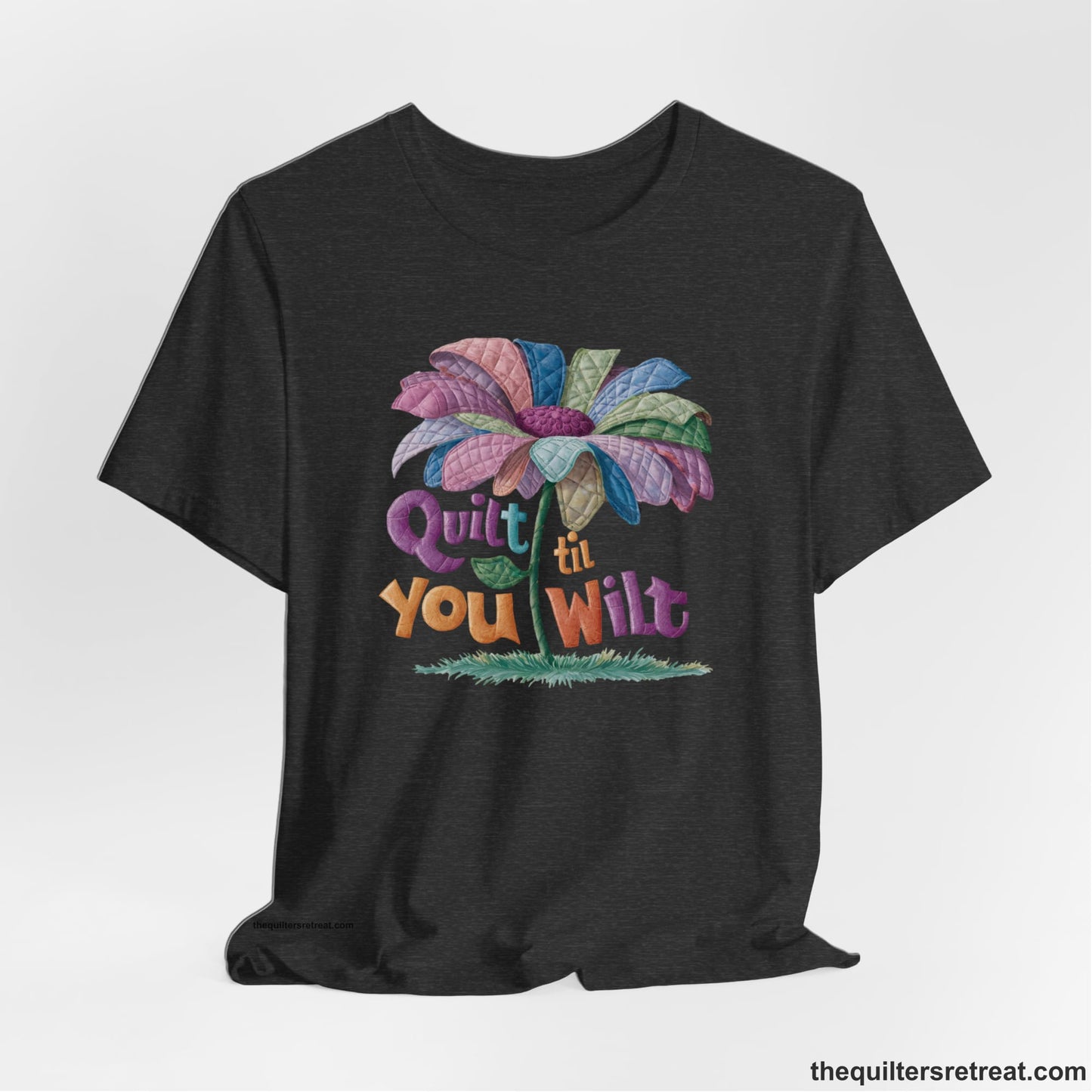 A Dark Grey Heather Short Sleeve T-Shirt with a whimsical quilted flower with bold "Quilt til You Wilt" text