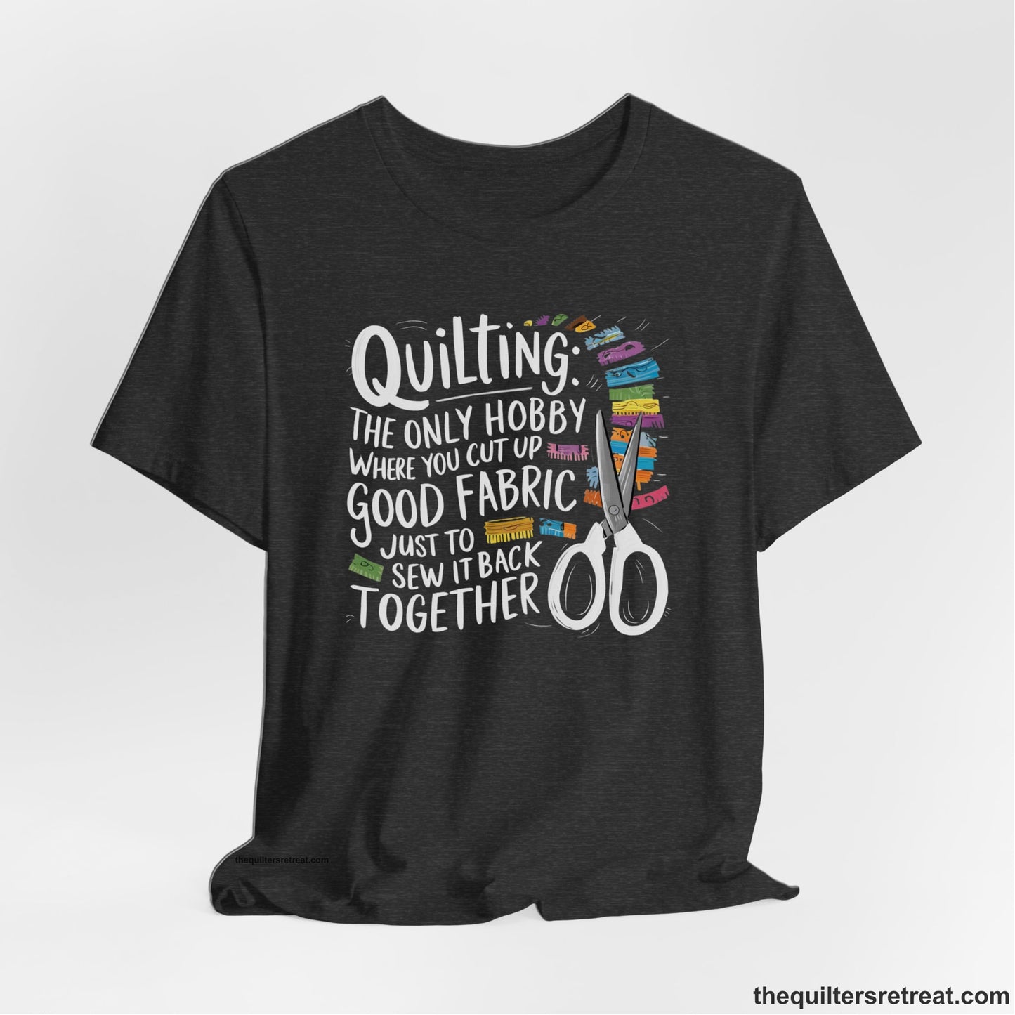 A Dark Grey Heather Short Sleeve T-Shirt with a quilting-themed text with colorful fabric pieces and scissors in a whimsical style