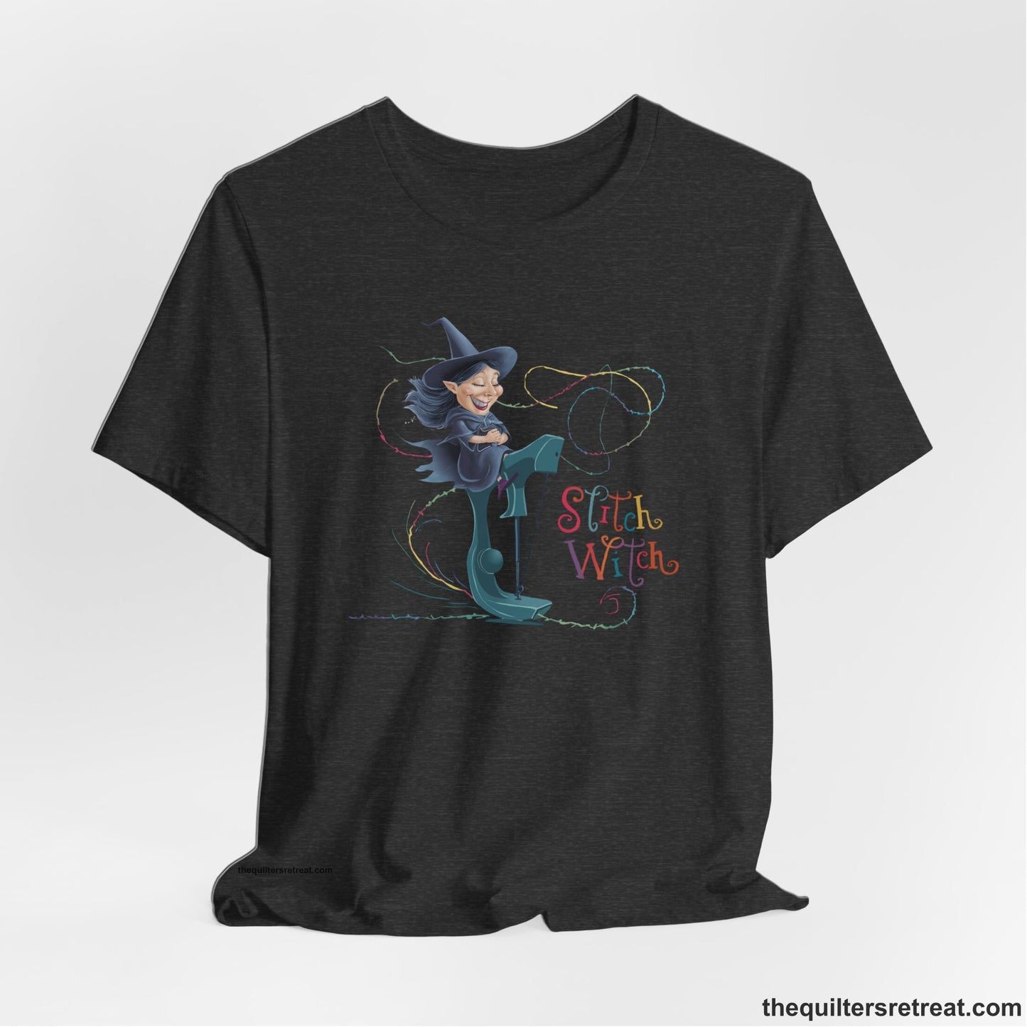 A Dark Grey Heather Short Sleeve T-Shirt with a witch on vintage sewing machine with "Stitch Witch" text in playful, colorful style