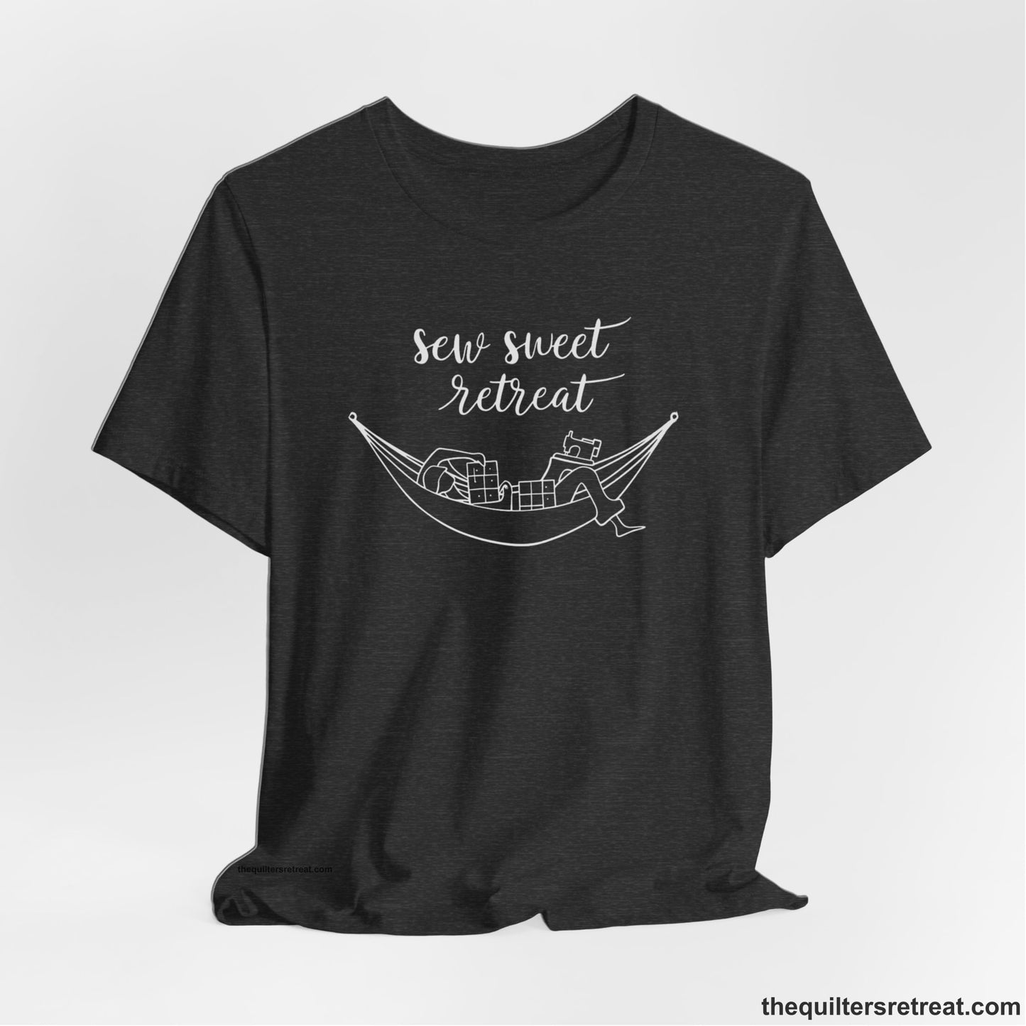 A Dark Grey Heather Short Sleeve T-Shirt with a sewing machine and thread spools with "Sew Sweet Retreat" in whimsical script