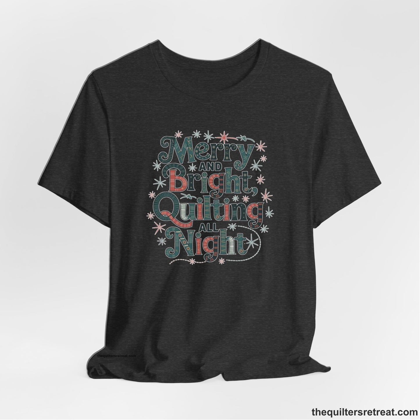 A Dark Grey Heather Short Sleeve T-Shirt with a Merry and Bright Quilting All Night text with festive patterns and stars in a whimsical style