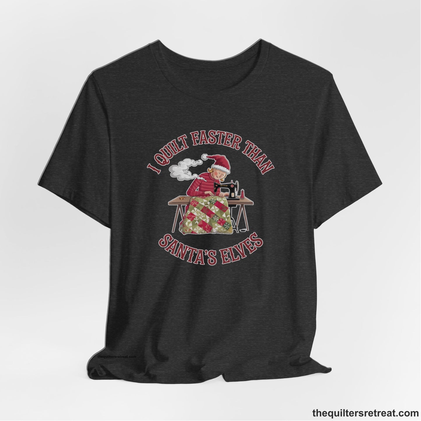 A Dark Grey Heather Short Sleeve T-Shirt with a whimsical illustration of a quilting woman with "I Quilt Faster Than Santa's Elves" text