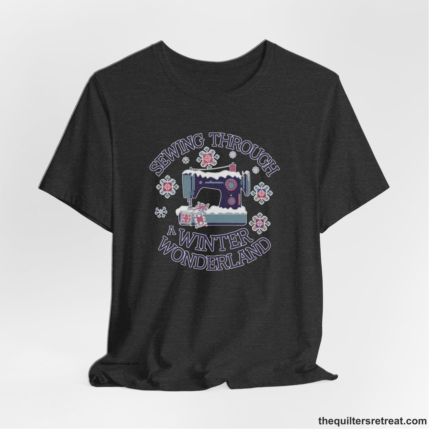 A Dark Grey Heather Short Sleeve T-Shirt with a sewing machine covered in snow with festive quilting elements and "Sewing Through a Winter Wonderland" text
