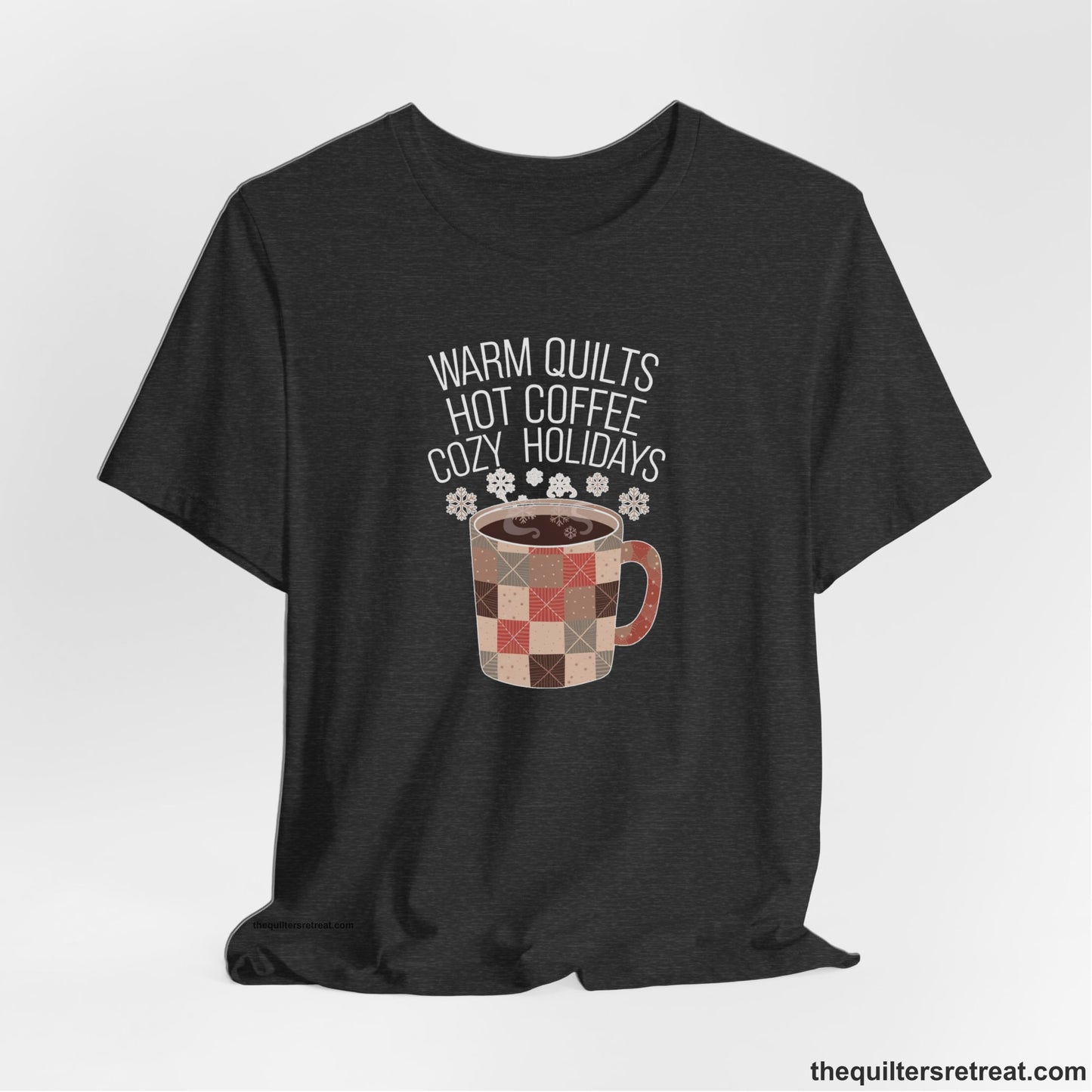 A Dark Grey Heather Short Sleeve T-Shirt with a warm quilts hot coffee cozy holidays text with a patchwork mug and snowflakes
