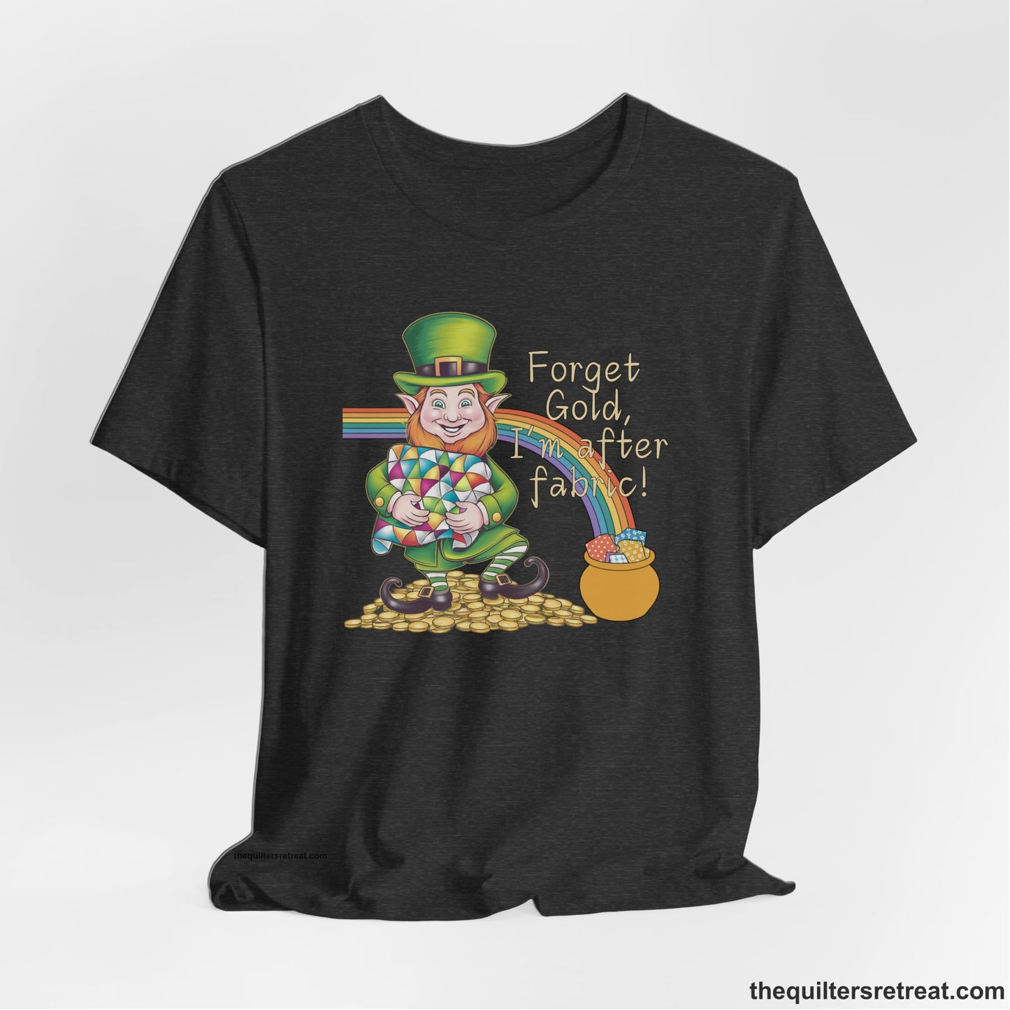 A Dark Grey Heather Short Sleeve T-Shirt with a leprechaun with colorful quilt and rainbow, whimsical "Forget Gold, I'm after fabric!" text