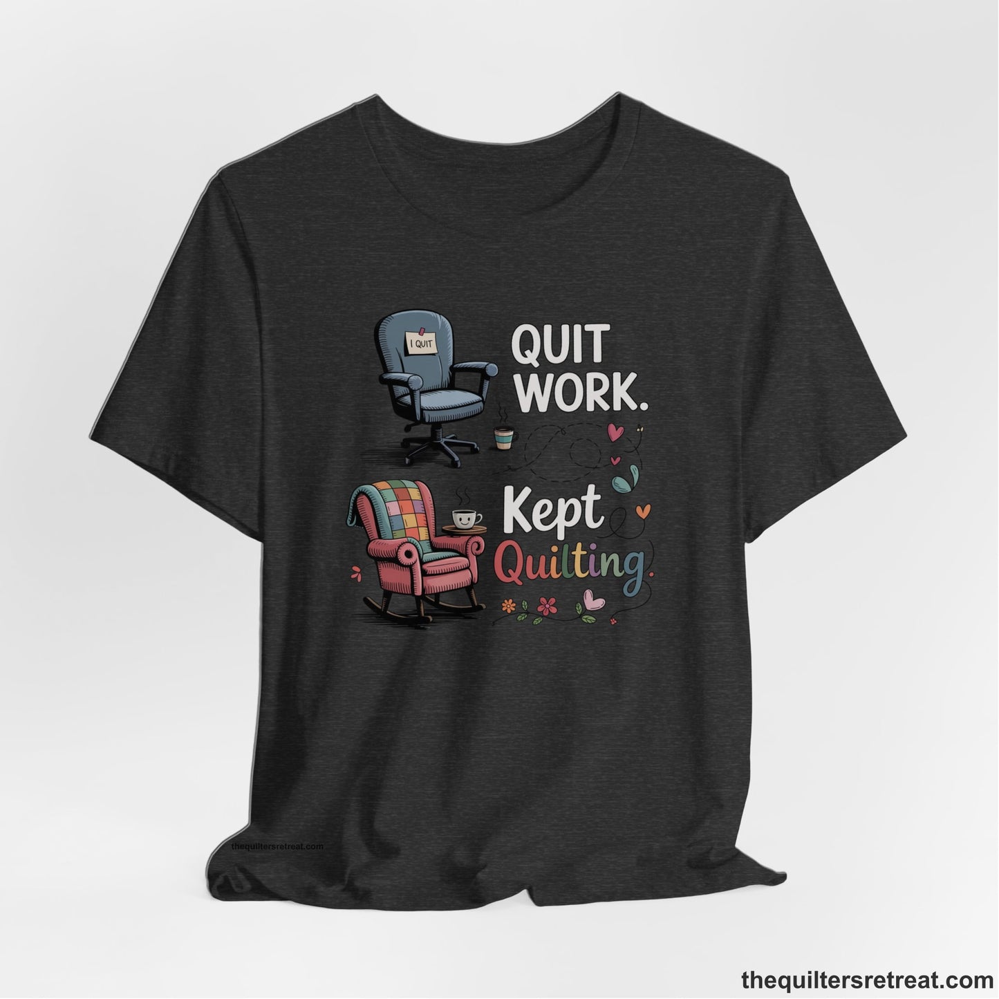 A Dark Grey Heather Short Sleeve T-Shirt with a quit work kept quilting text with cozy chairs and colorful floral accents in a whimsical style