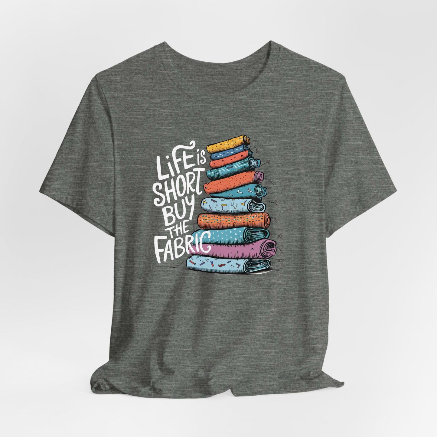 A Deep Heather Short Sleeve T-Shirt with a illustration of colorful fabric rolls with bold "Life is Short Buy the Fabric" text